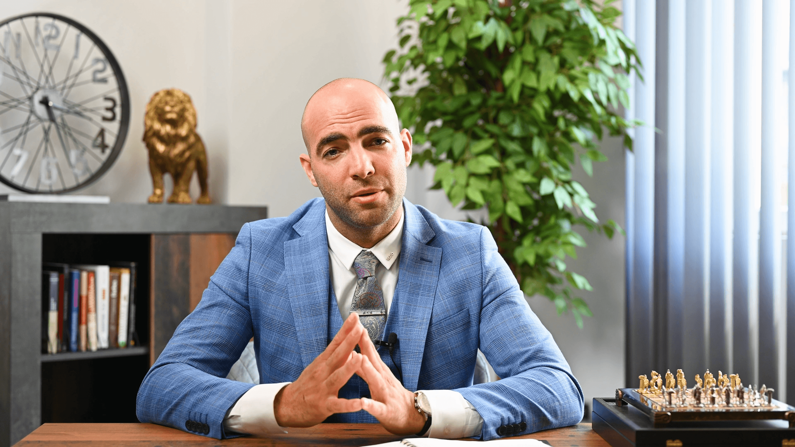 A man in an expensive suit sitting at a table