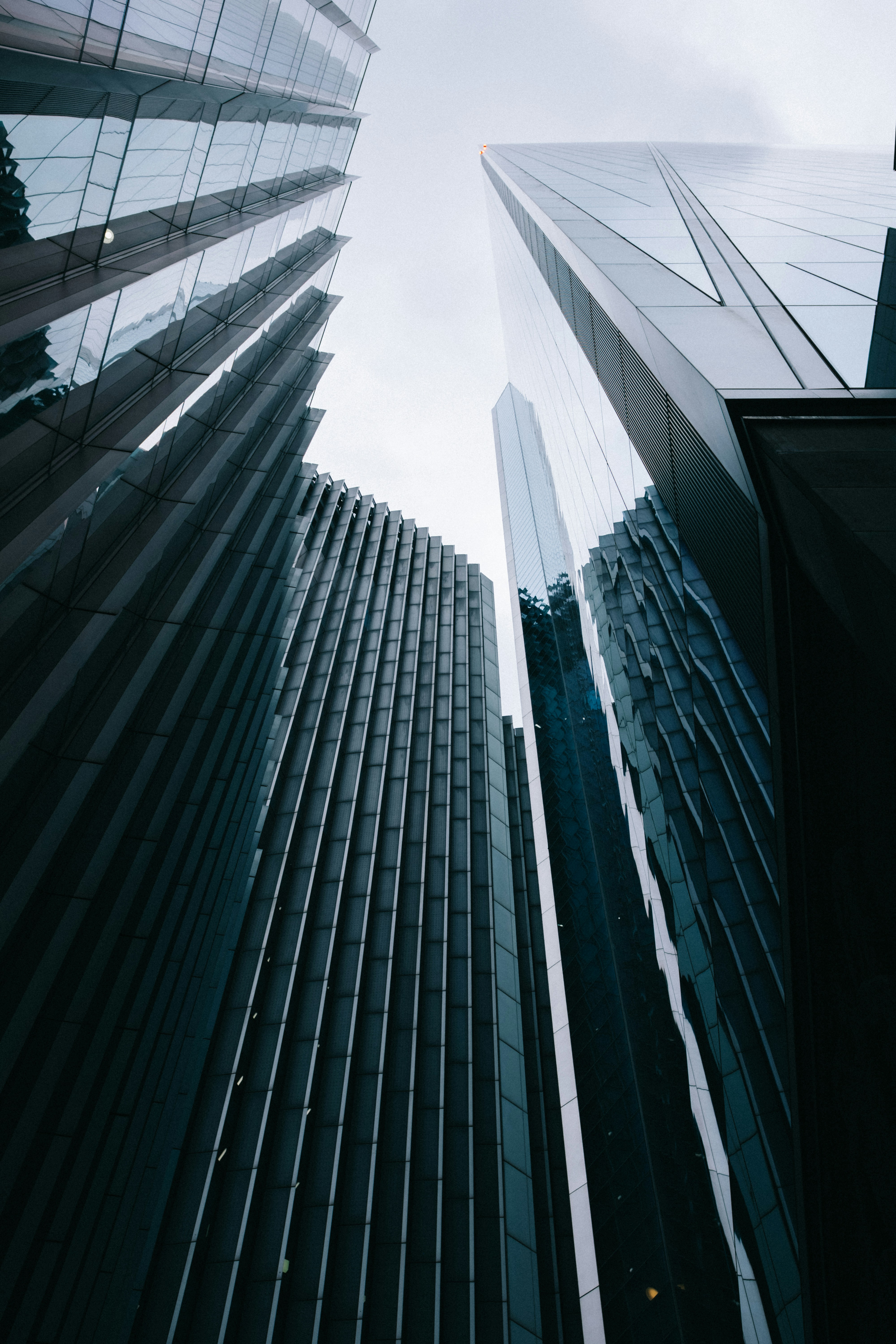 Modern glass skyscrapers reaching towards a cloudy sky