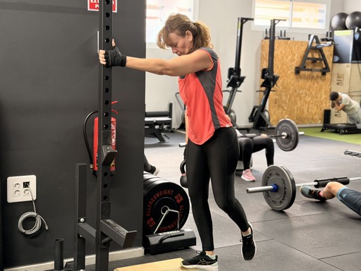 woman in black tank top sitting on brown wooden bench