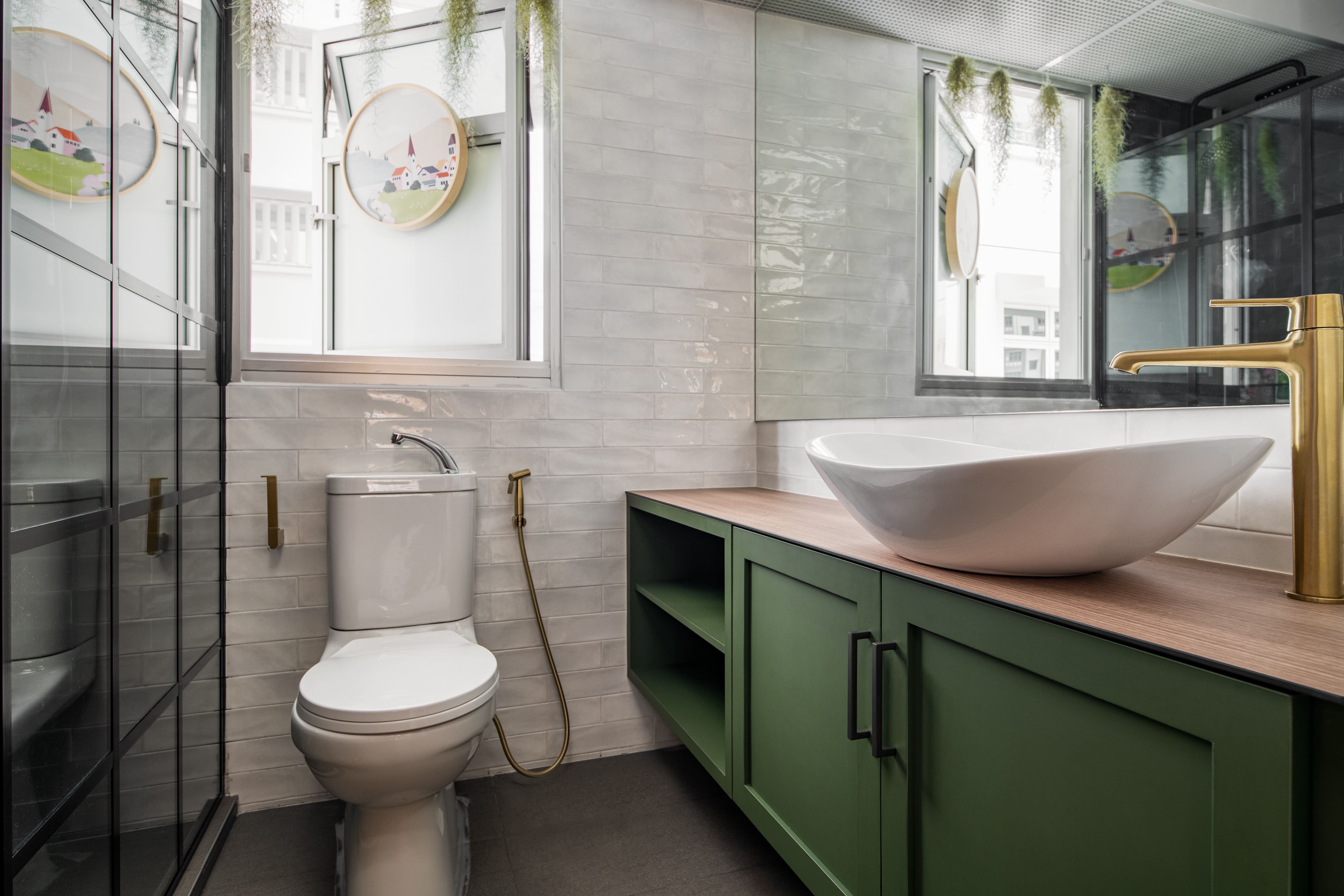 Bathroom with deep green cabinetry, wood countertop, and a sculptural basin, accented by gold fixtures for a touch of luxury.