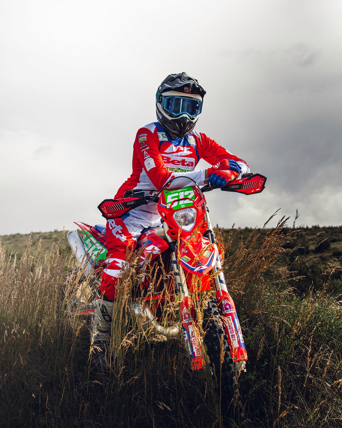A woman in a straw hat stands in the grass