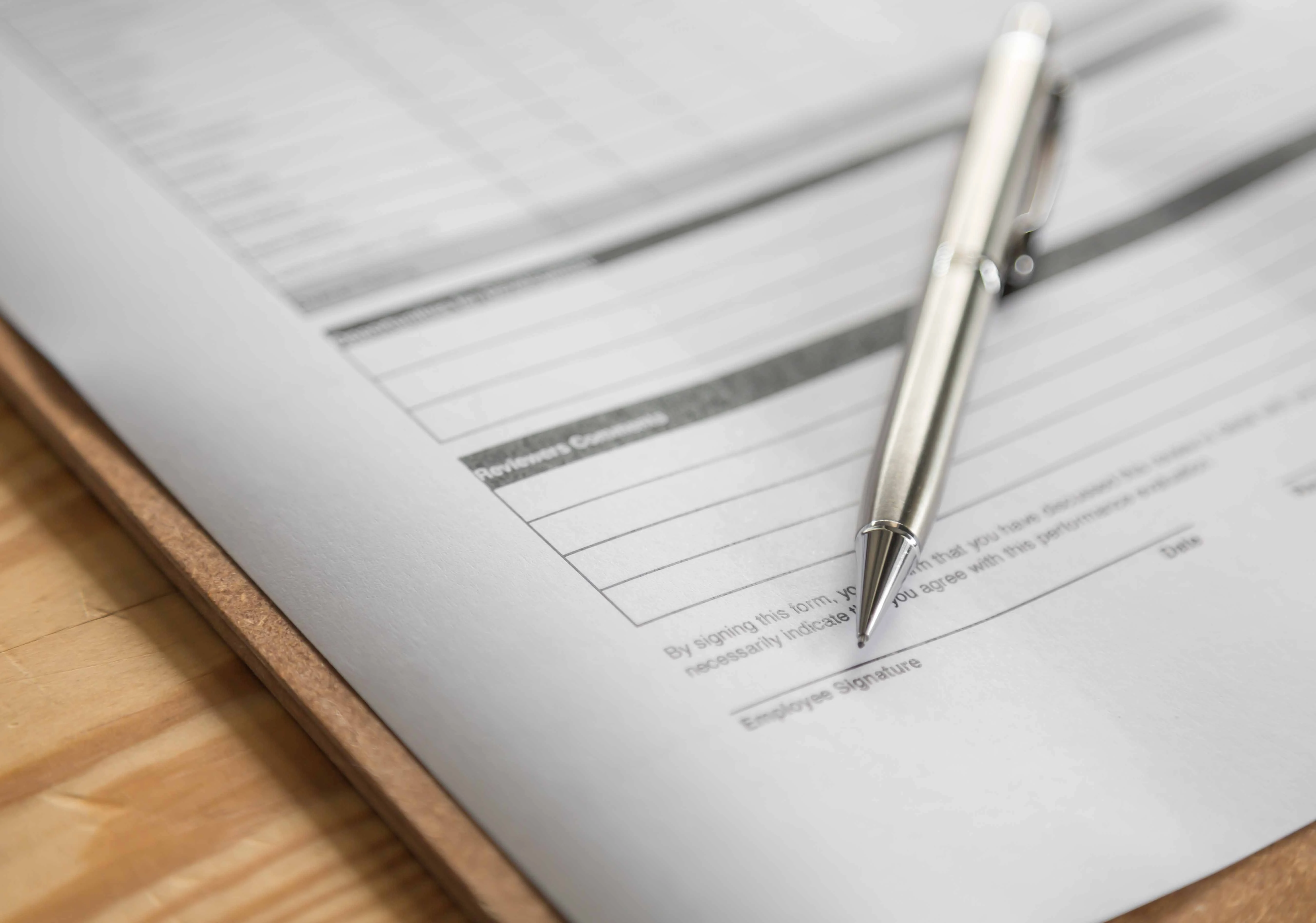 people sitting on chair in front of table while holding pens during daytime