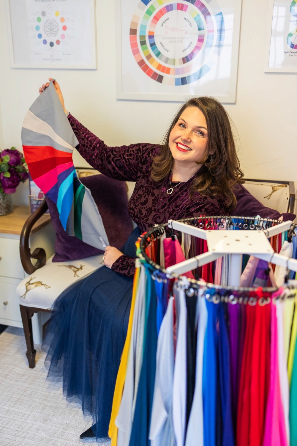 Lucy, next to a colour wheel, showcasing her fabric swatches.