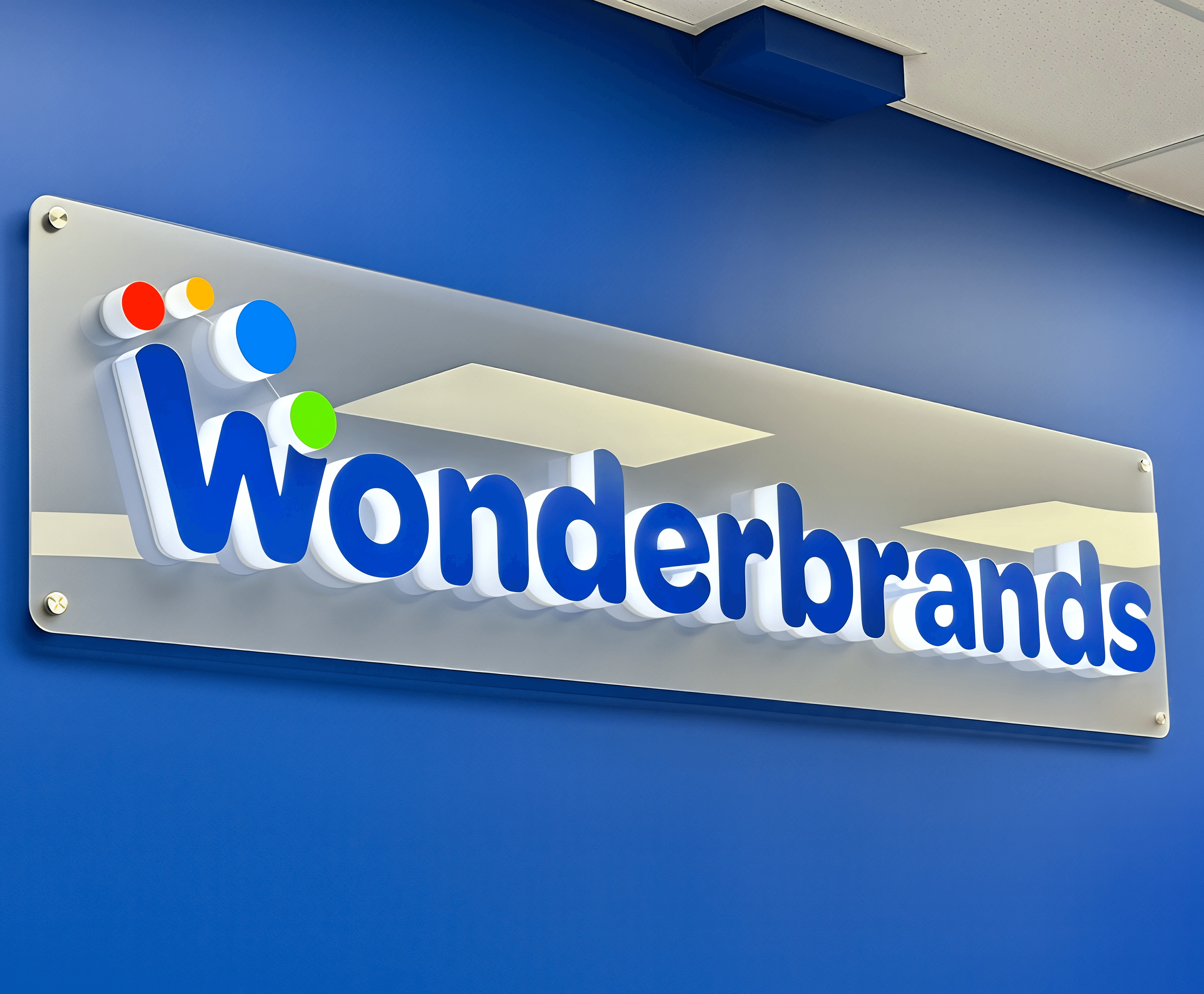 Custom LED backlit 3D dimensional reception sign with frosted clear acrylic back panel mounted on standoffs for Wonderbrands in the Manchester Industrial area of southeast Calgary.