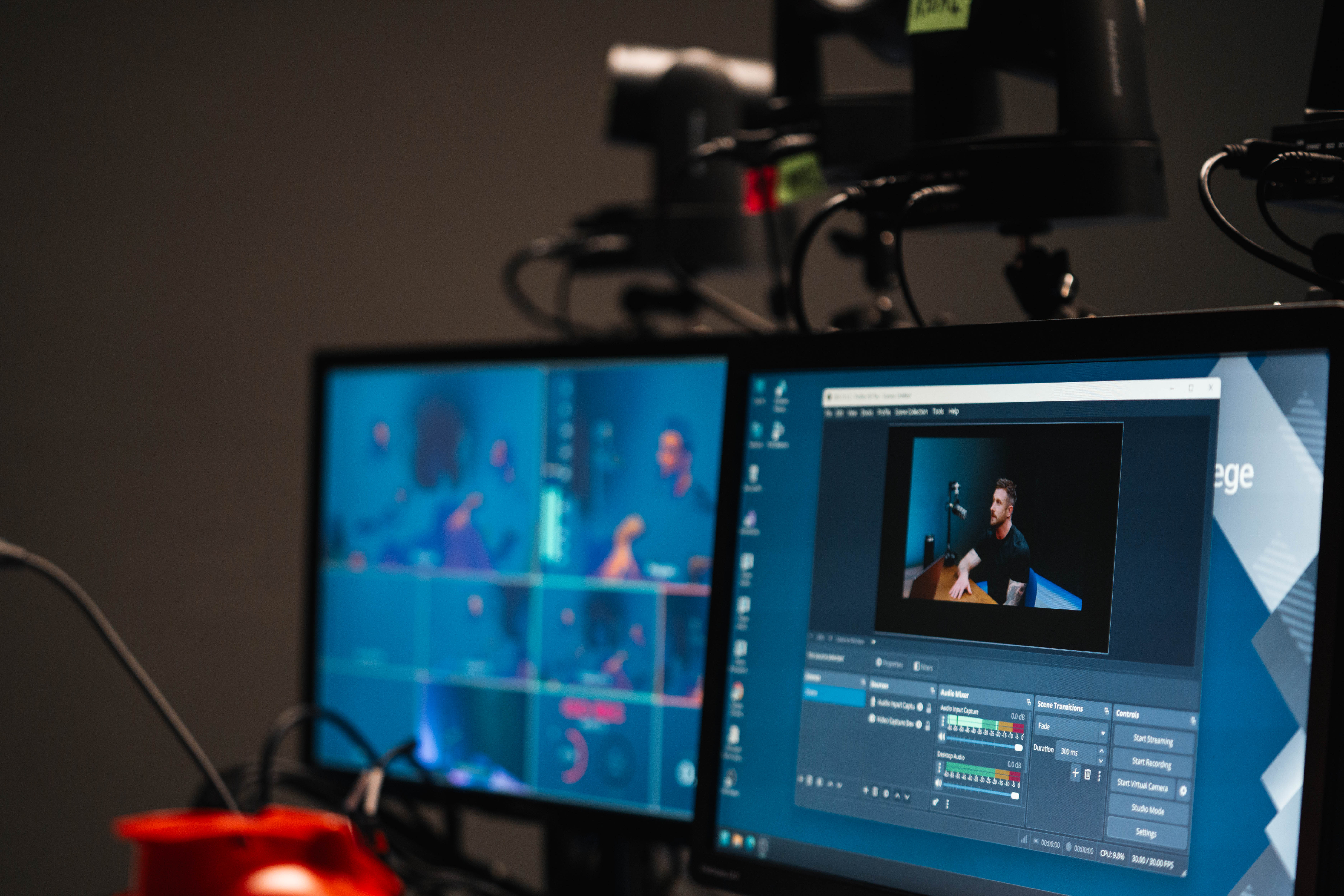 Behind-the-scenes production monitors showing a presenter on set