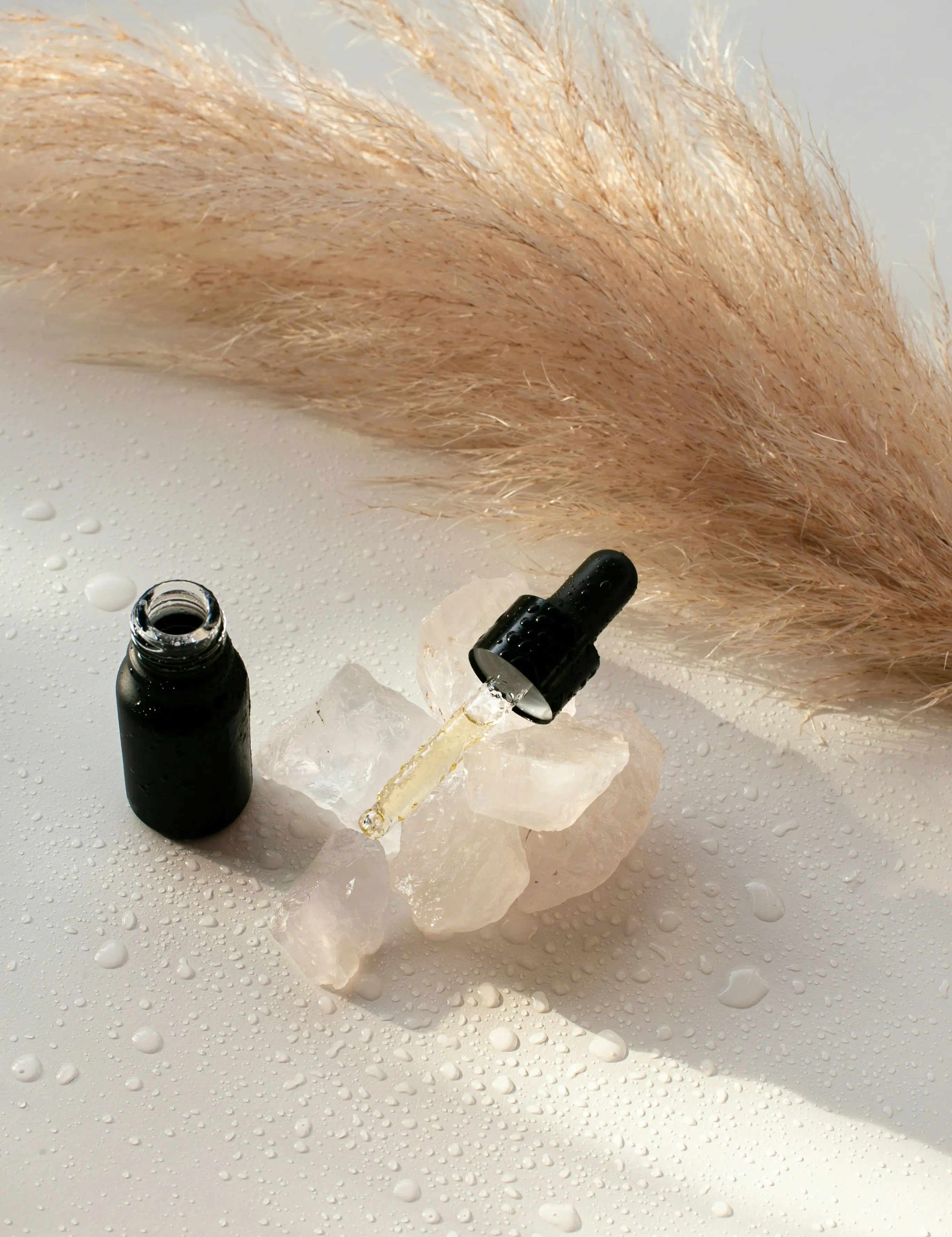 Best essential oils for detox bath setup with dropper bottle and natural pampas grass decoration