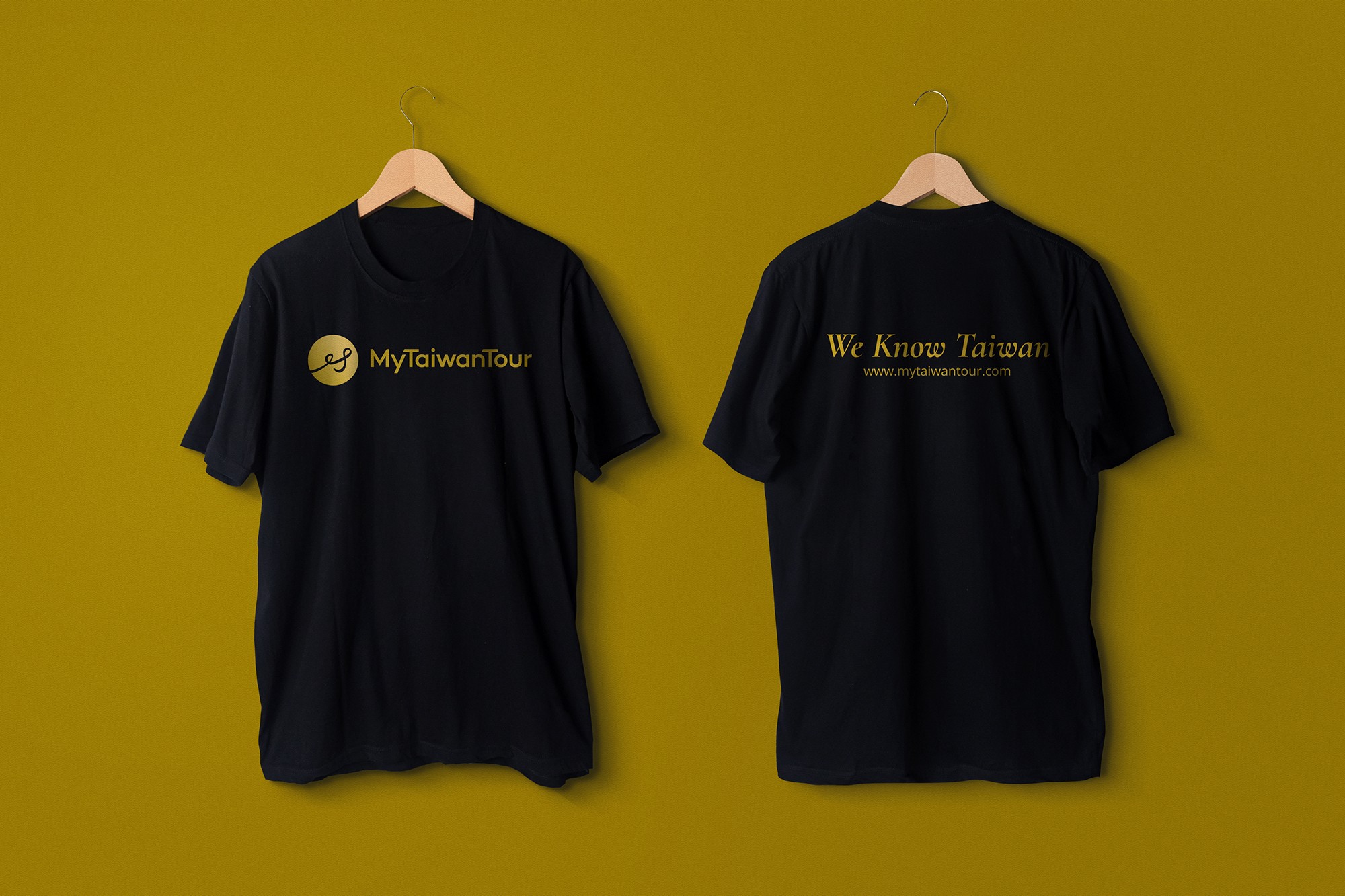 這張圖像展示了 MyTaiwanTour 的 T 恤設計。前面T恤有金色的 MyTaiwanTour 標誌和字樣。背面有金色的 "We Know Taiwan" 字樣和網站地址。