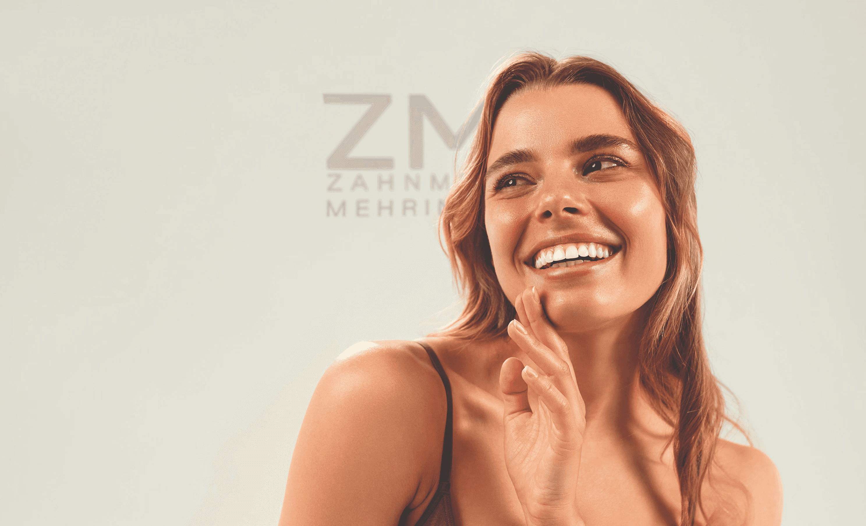 Close-up portrait of a woman with long red hair, closed eyes, and a soft expression, against a beige background