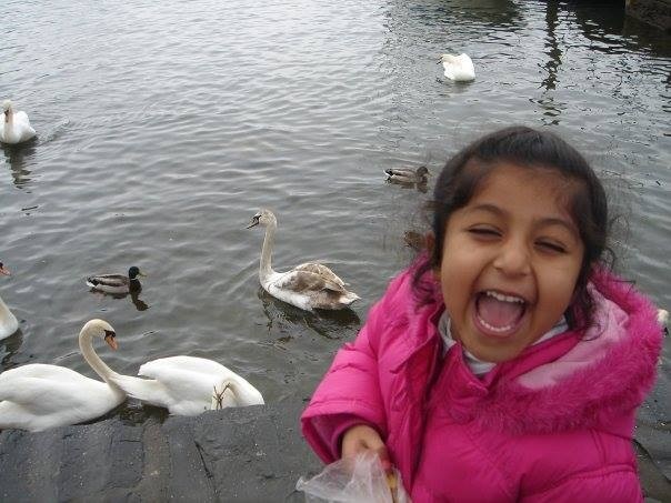 A close-up of a person wearing green-tinted glasses, with a serious expression and smooth skin.