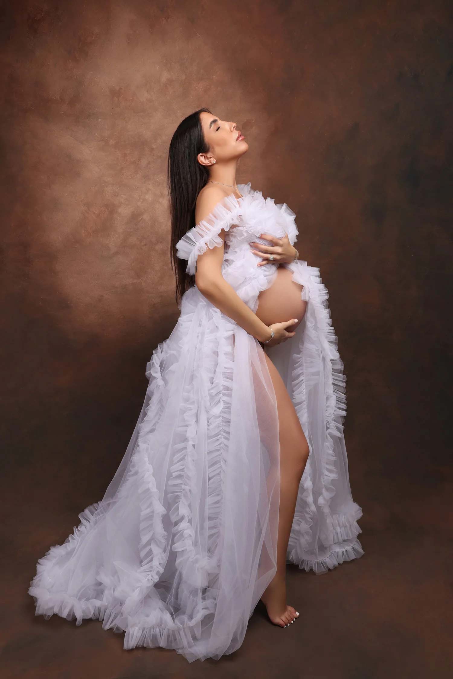 Maternity portrait of a woman in a flowing white gown