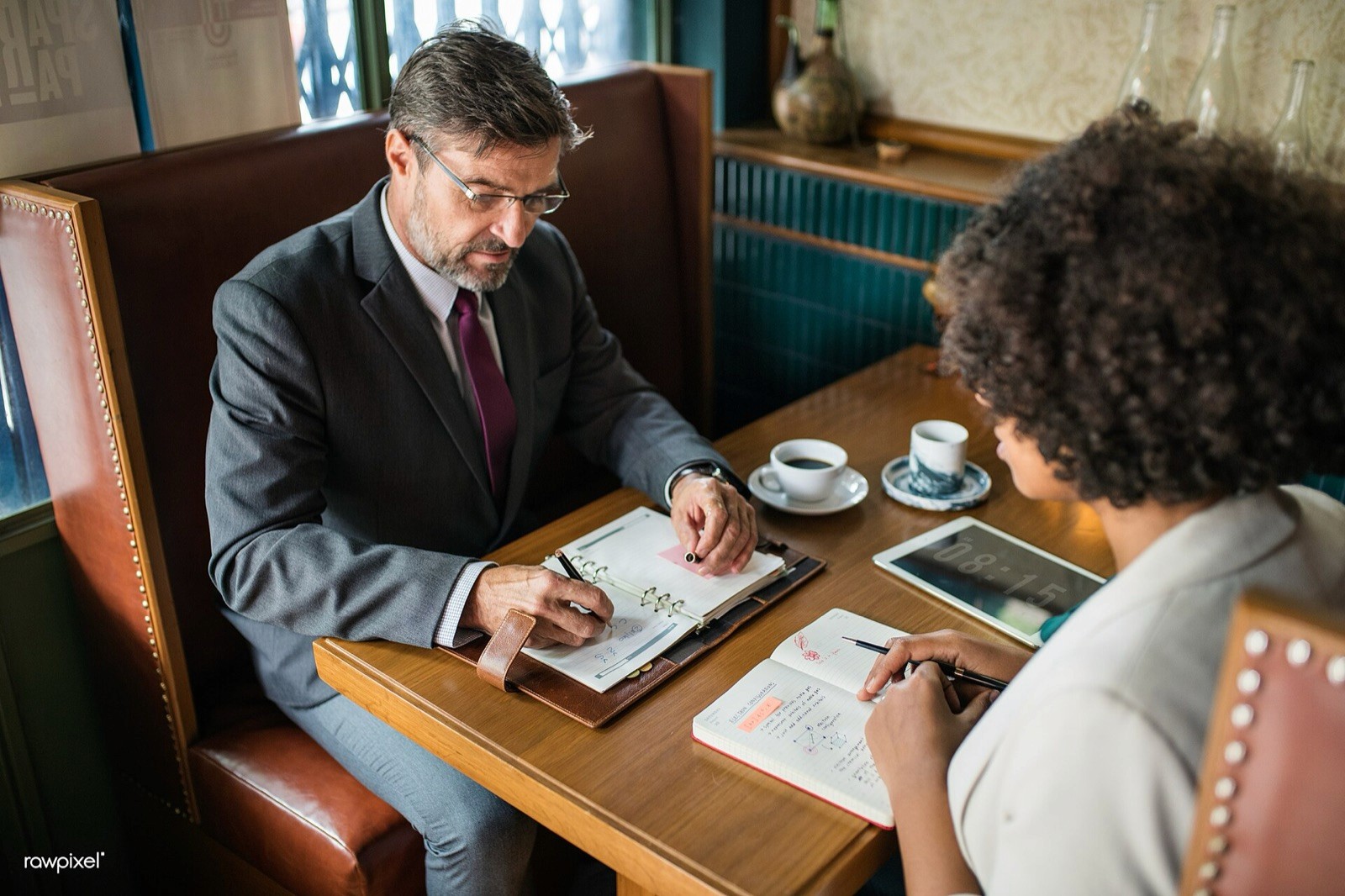 Twee mensen in gesprek aan een tafel, de werkeenheid van een accountplan.