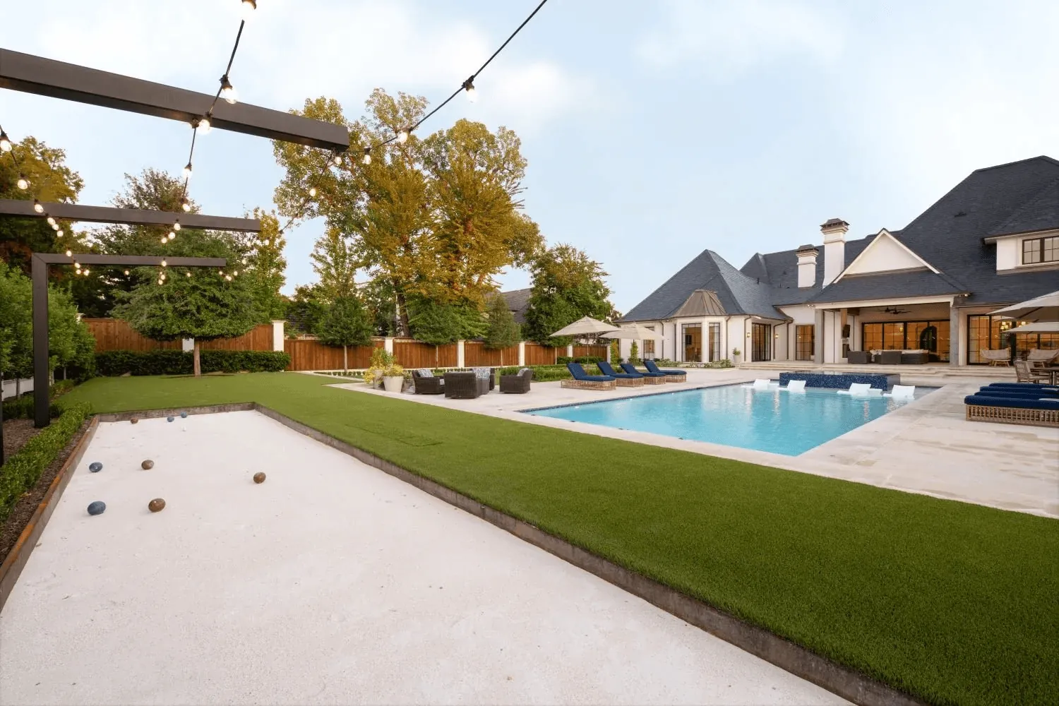 Custom bocce ball court with oyster shell surface and shade structure for Preston Hollow Dallas estate