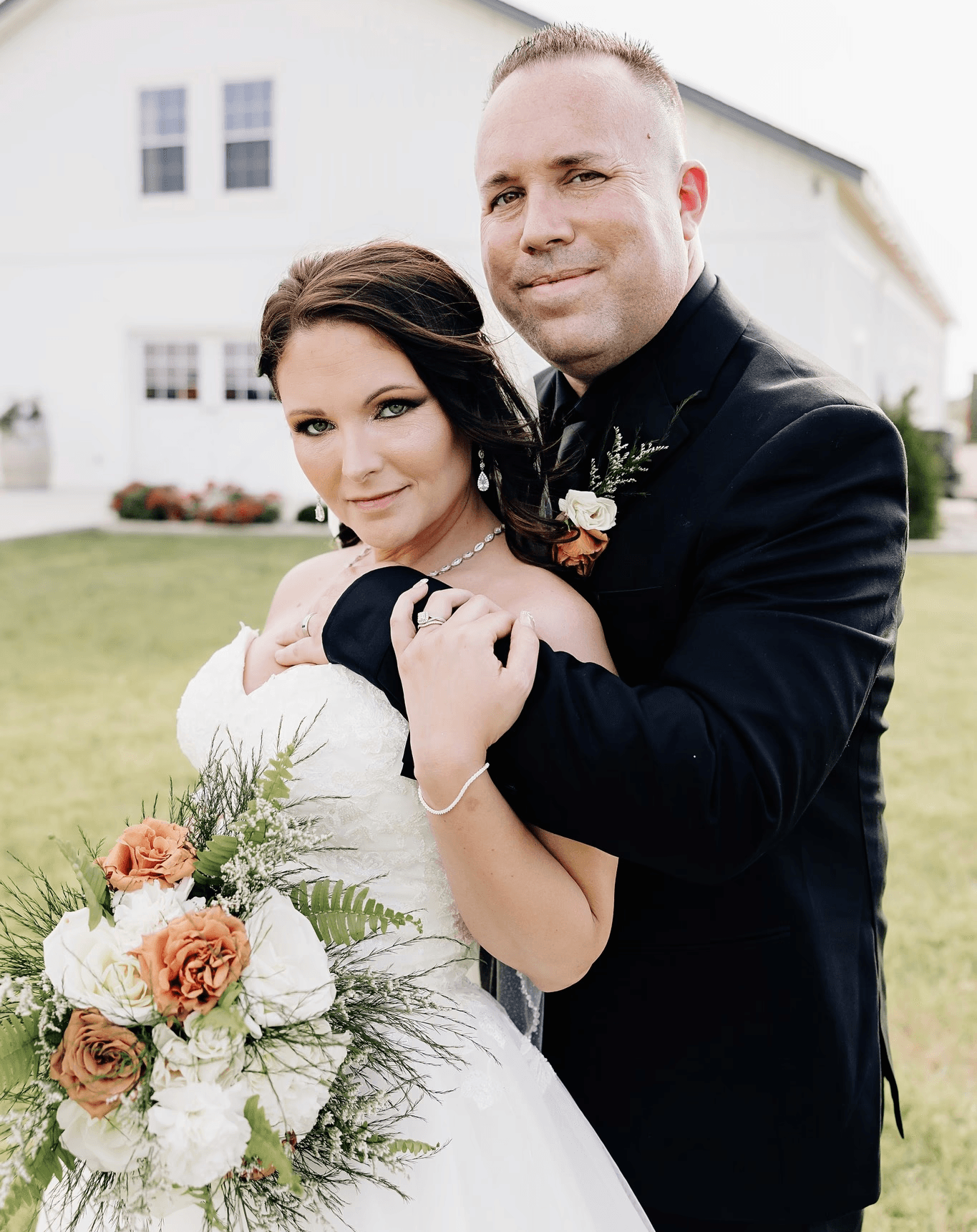 A person with shoulder-length blonde hair wearing a black newsboy cap and a black sweater.