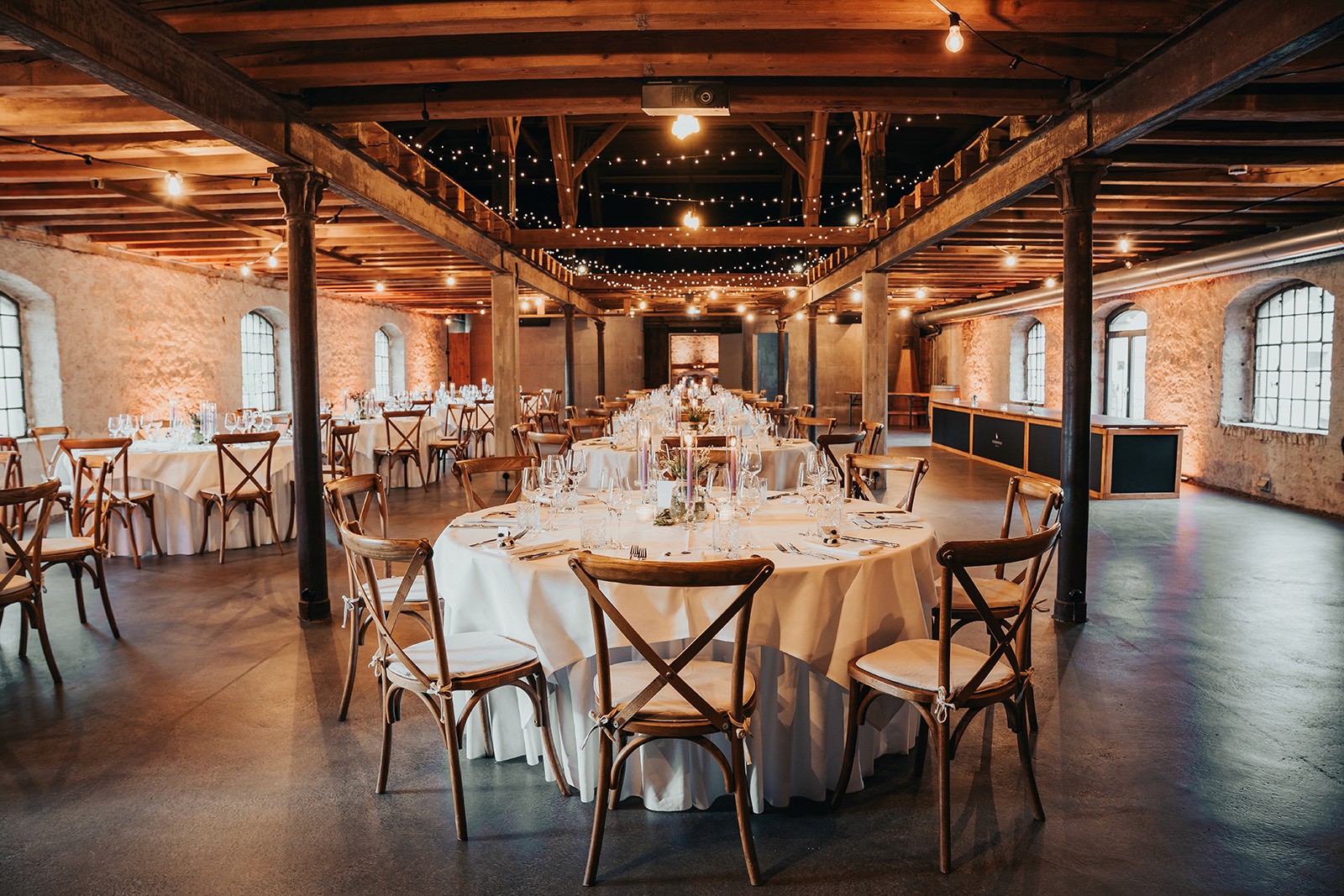 Person balancing on rocks by the ocean at sunset