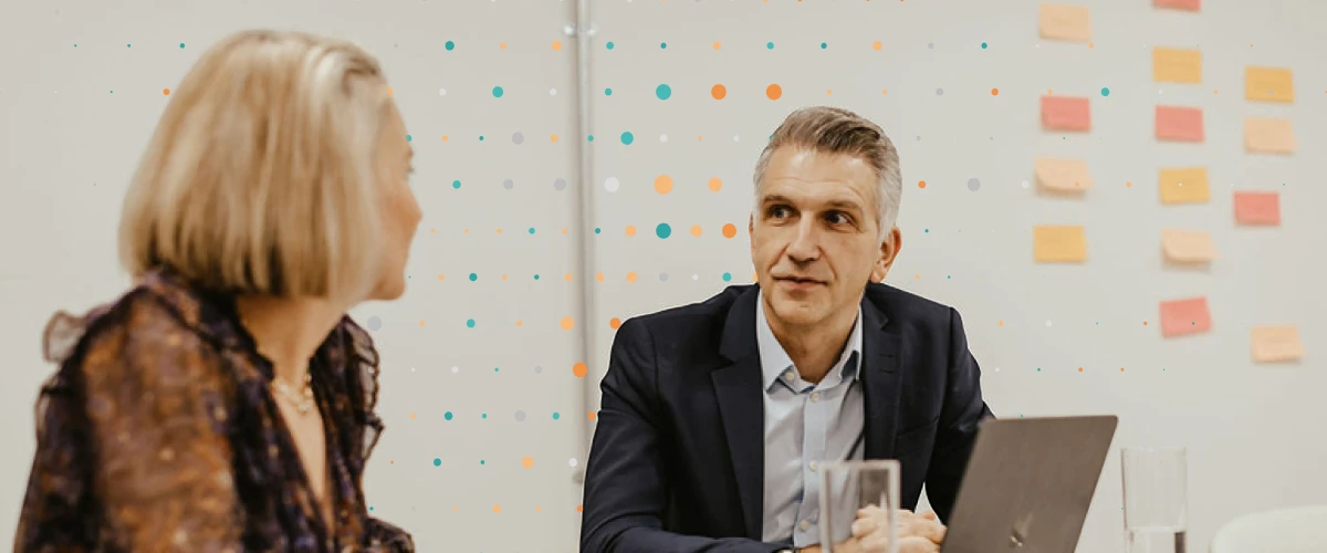 two consultants sitting at a desk around a laptop