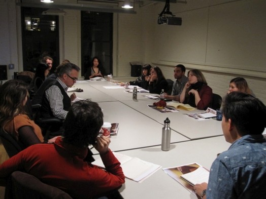 A photo of a group of people sitting at a conference table.