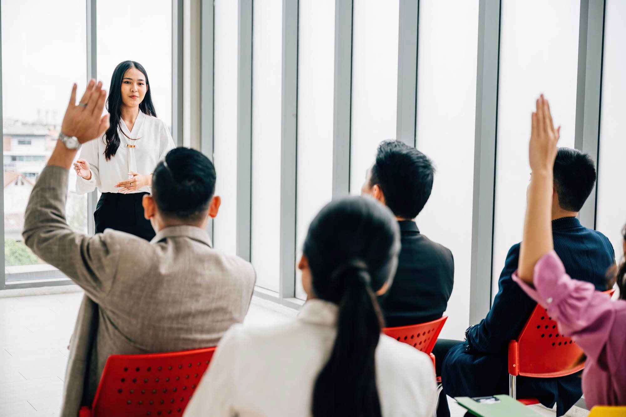 研討會互動環節中講者向台下提問，觀眾舉手發言與參與投票，提升參與度與記憶點，讓活動更容易轉化與被分享 Seminar interaction session with speaker taking questions and audience responding via hand raising and live polling boosting engagement and recall 研討會互動設計 觀眾參與度 活動轉化