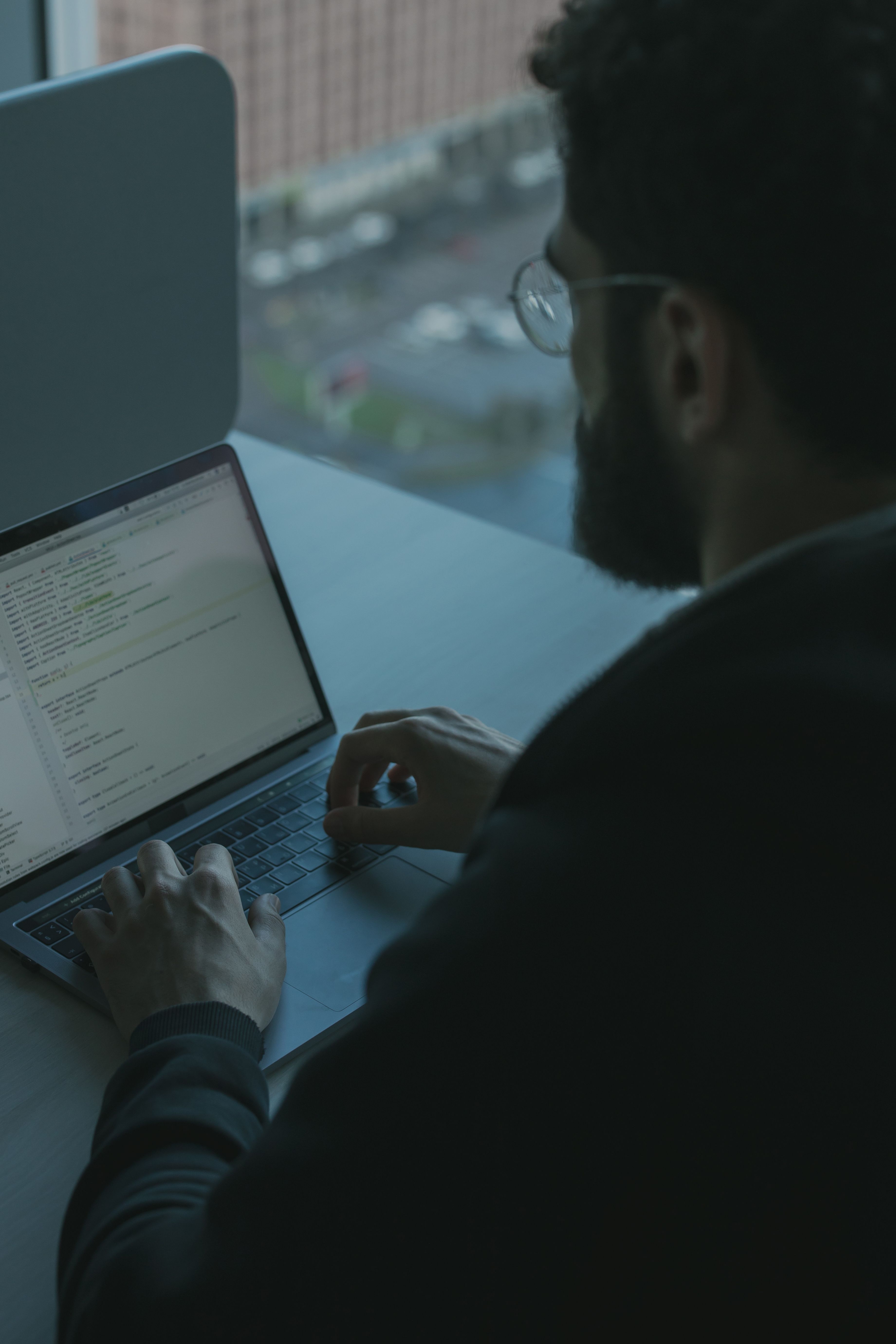 Person working on a laptop with code 