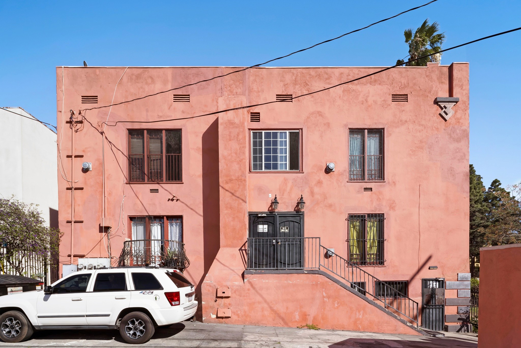 Rear building view showing unit access, windows, and parking area at 101 N Kenmore Ave.