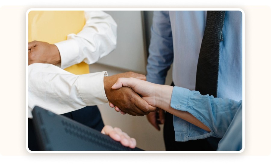 Two professionals shaking hands in a formal supplier agreement