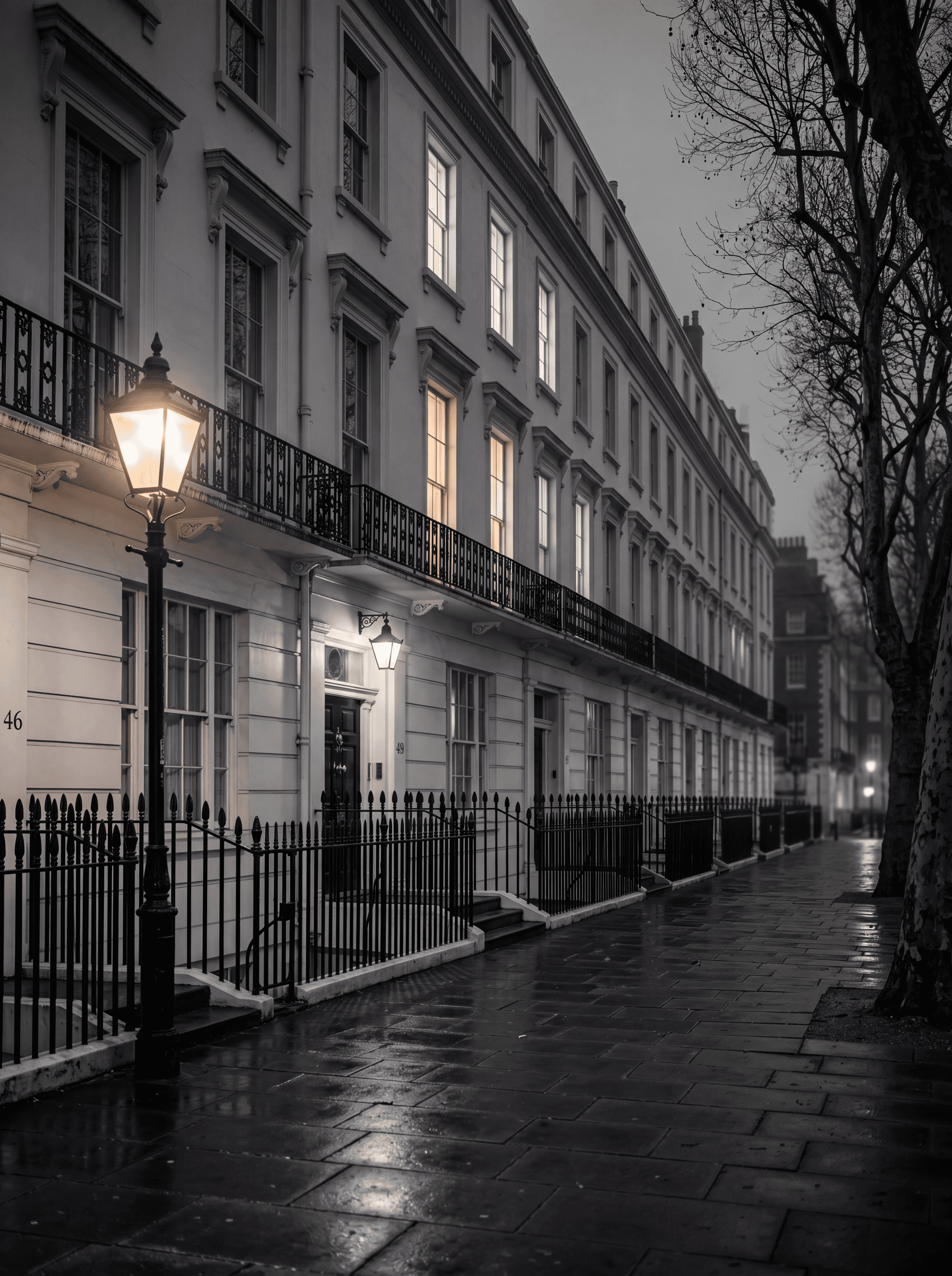 Bloomsbury Georgian terrace at dusk near UCL with warm interior lights and a Victorian street lamp, illustrating international student accommodation in London, monochrome editorial photograph