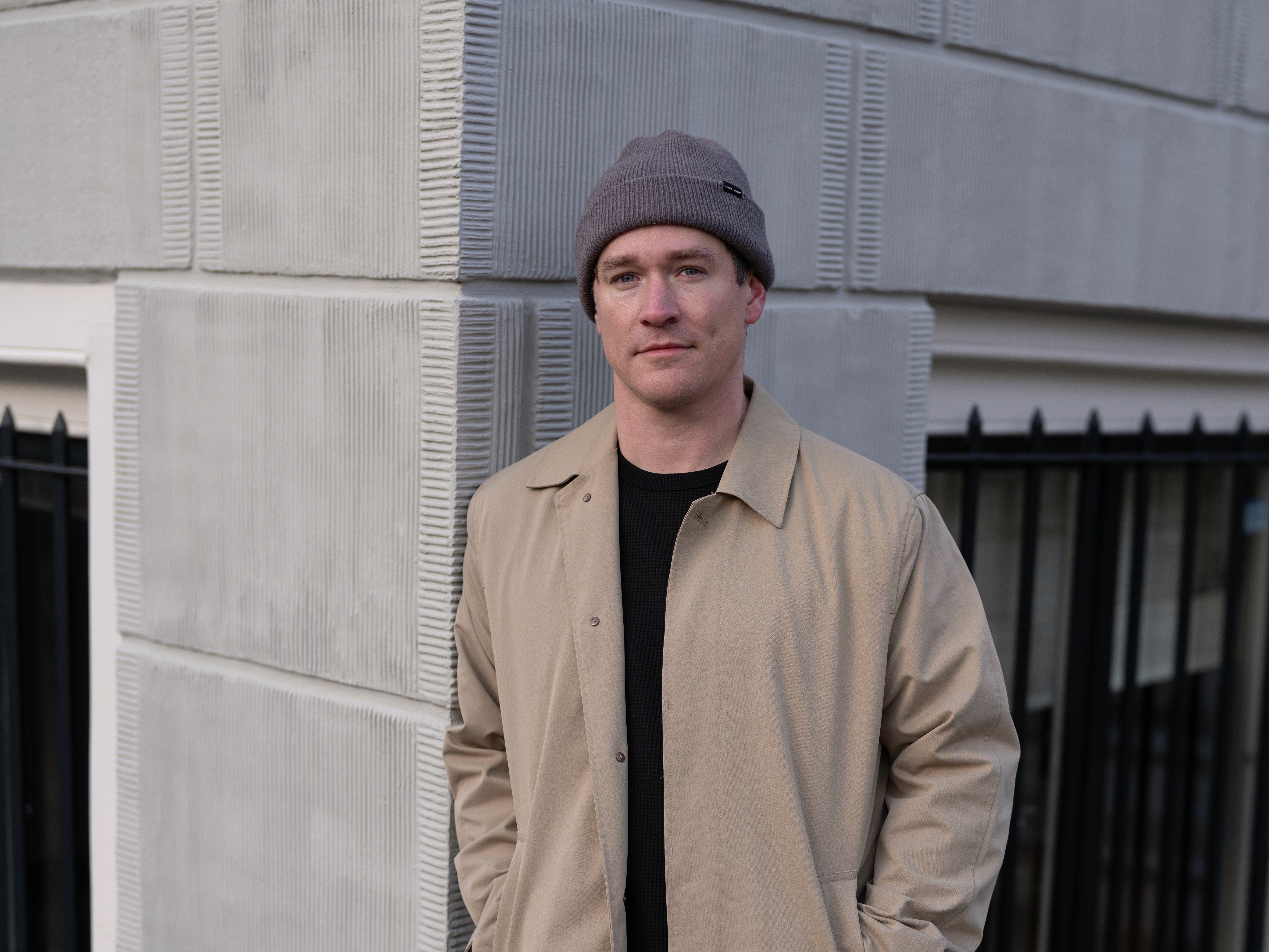 Close-up portrait of Brett, leaning against an Amsterdam canal house, looking into the camera.