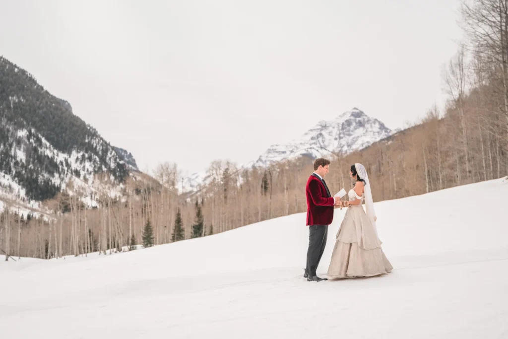 Bride and groom standing in snowy landscape during T-Lazy 7 elopement Aspen