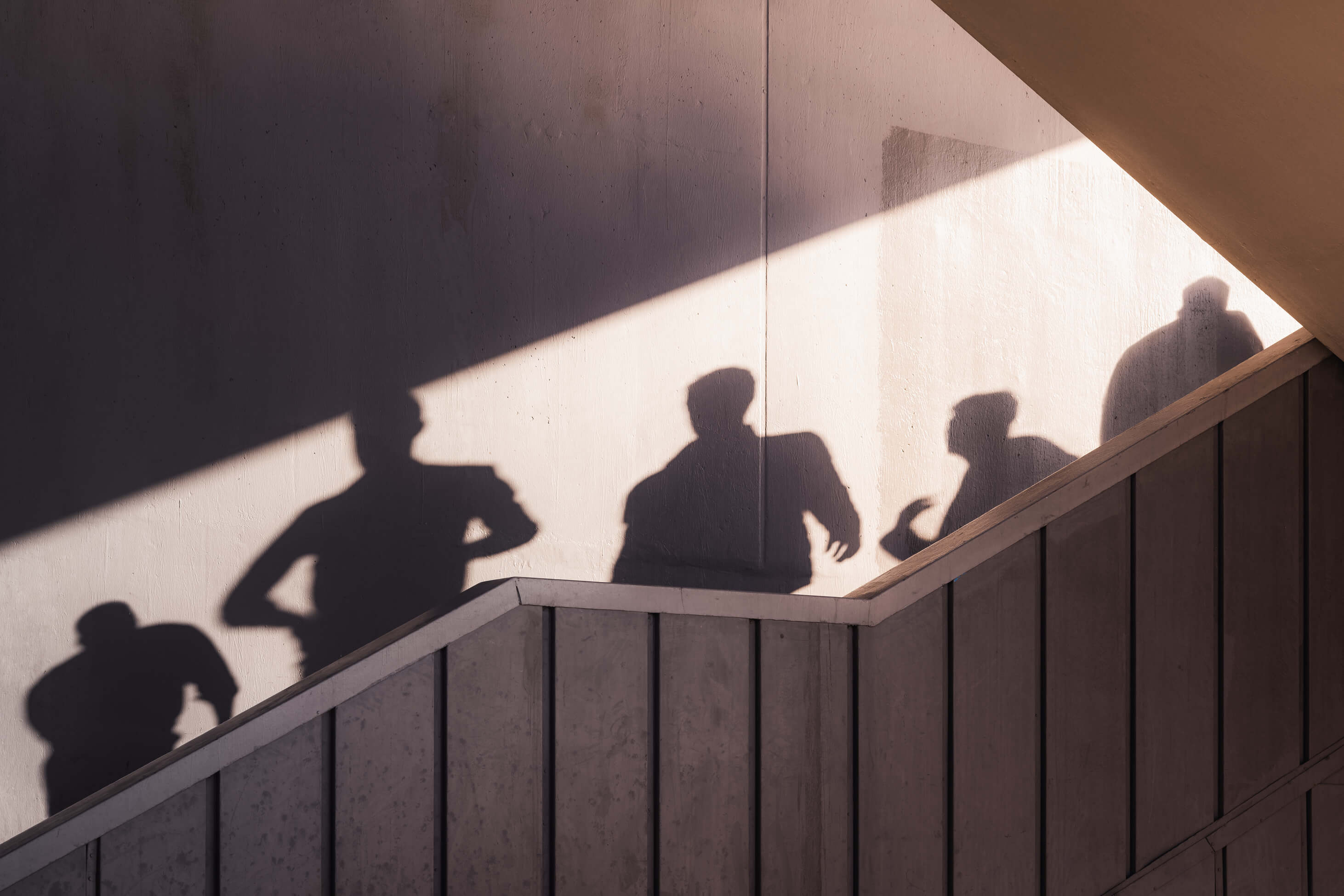 Black and white image of people working at a table with laptops, showing hands gesturing during discussion of digital content displayed on screens, with fabrica® logo in the corner.