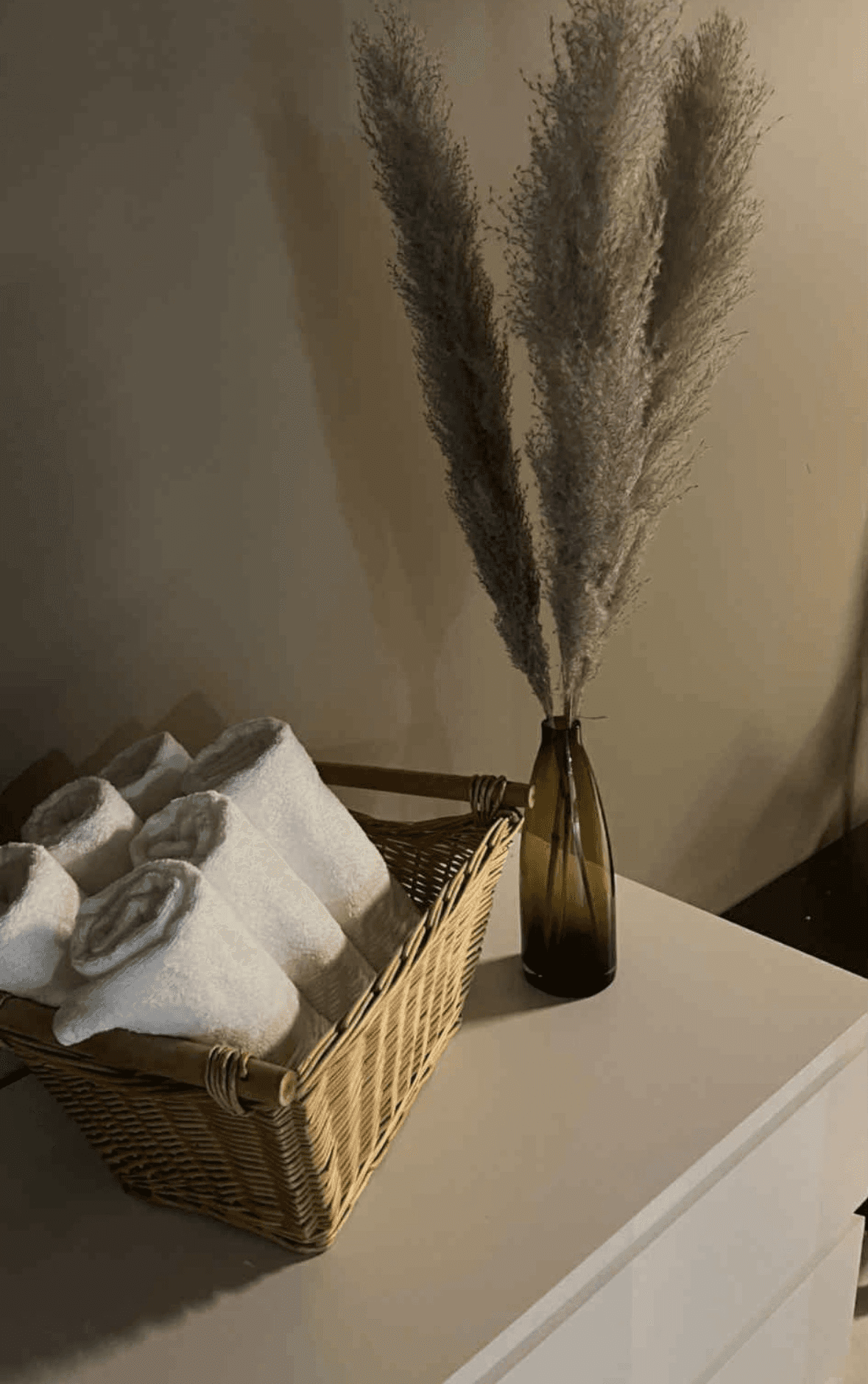 Neutral-toned clinic decor with folded towels and dried plants