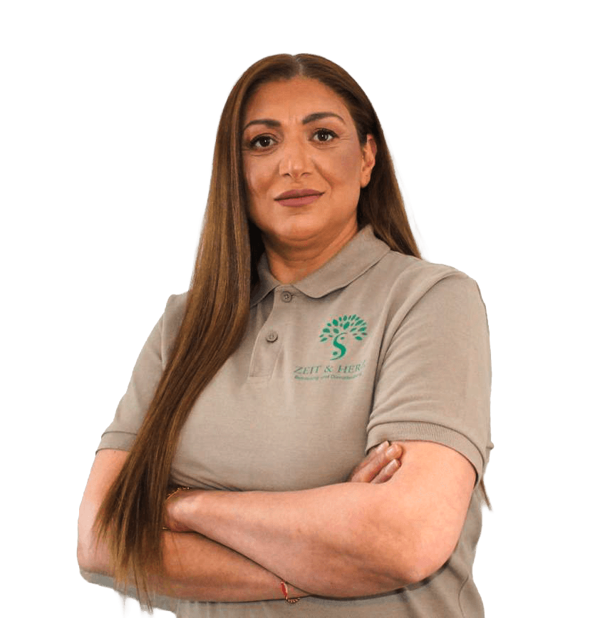 A woman sits cross-legged with eyes closed, wearing a white blouse and a long purple skirt, looking serene.