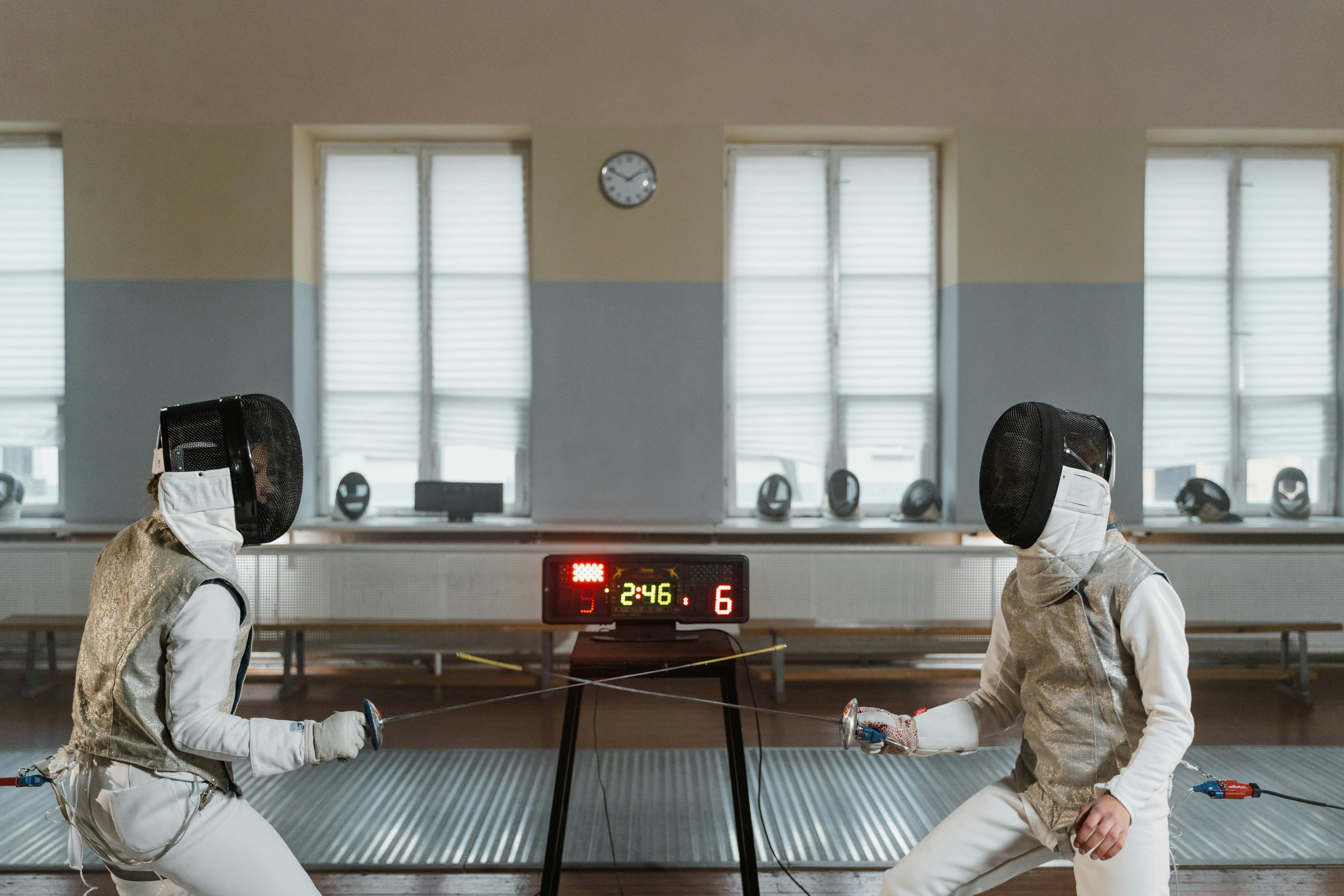 Fencers engaged in a bout with the scoreboard showing