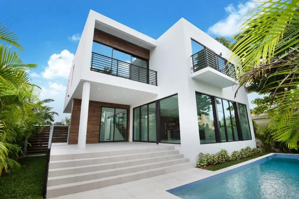 Rear facade of modern two-story home with pool and covered terrace in Miami Beach by Atelier International LLC