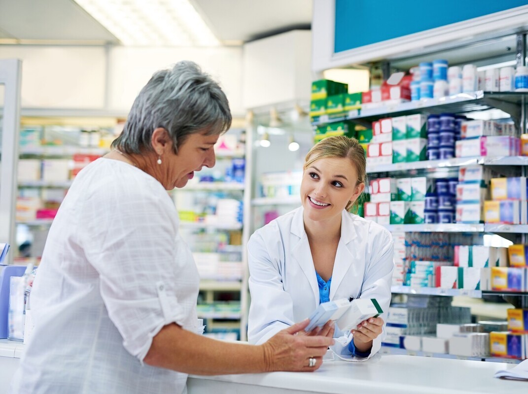 older woman at a pharmacy discussing weight loss pills that actually work with the pharmacist