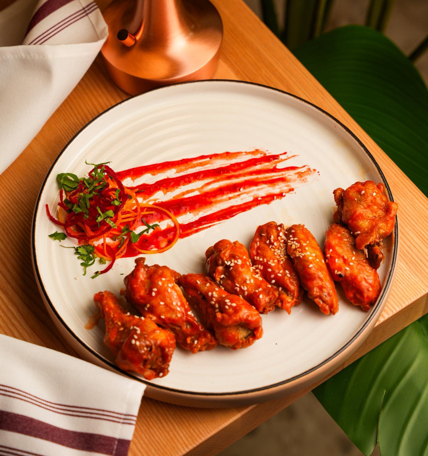 Spicy chicken wings tossed in a signature Indo-fusion glaze at Dhoom Indian restaurant in Greektown Toronto