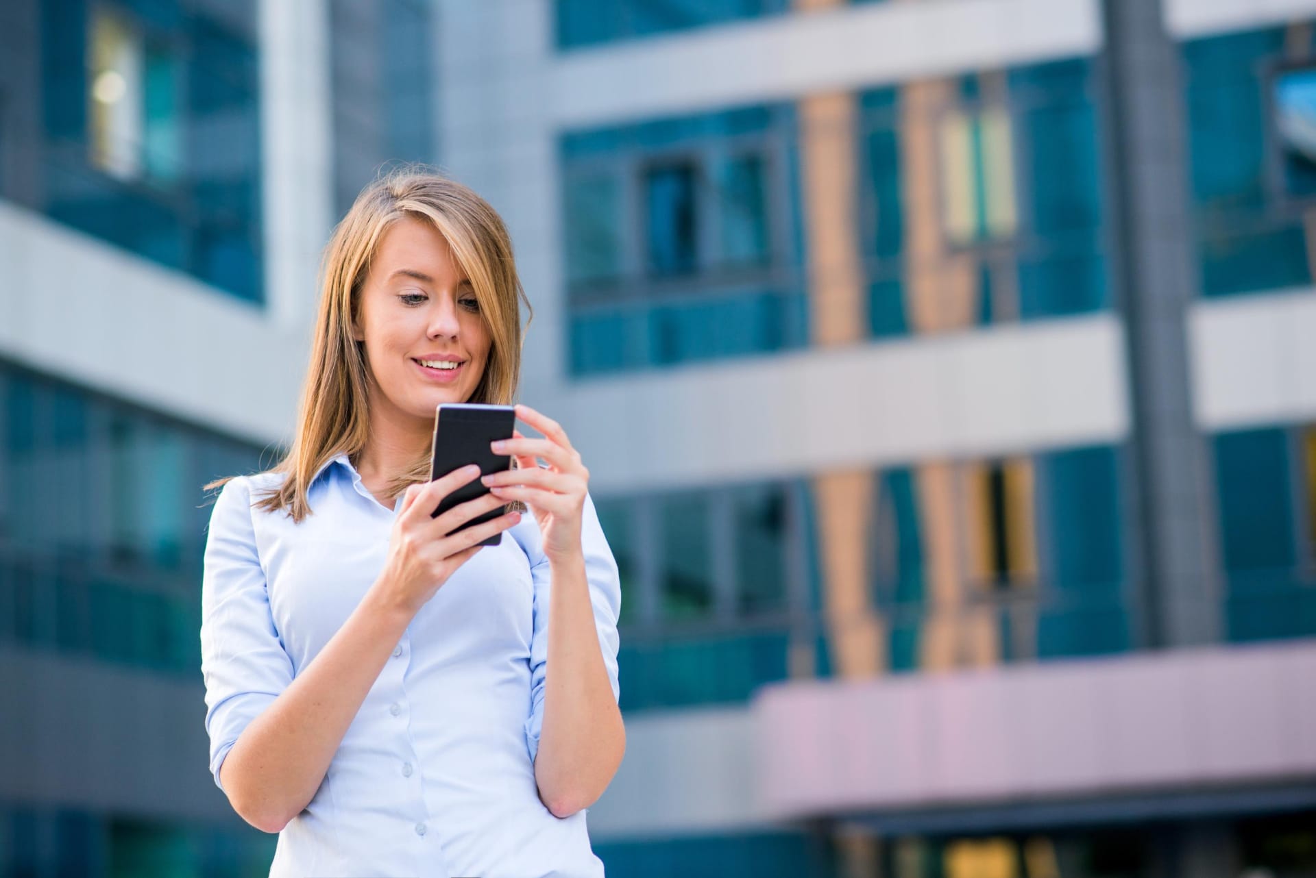 Smiling business woman listening to call on smartphone in front
