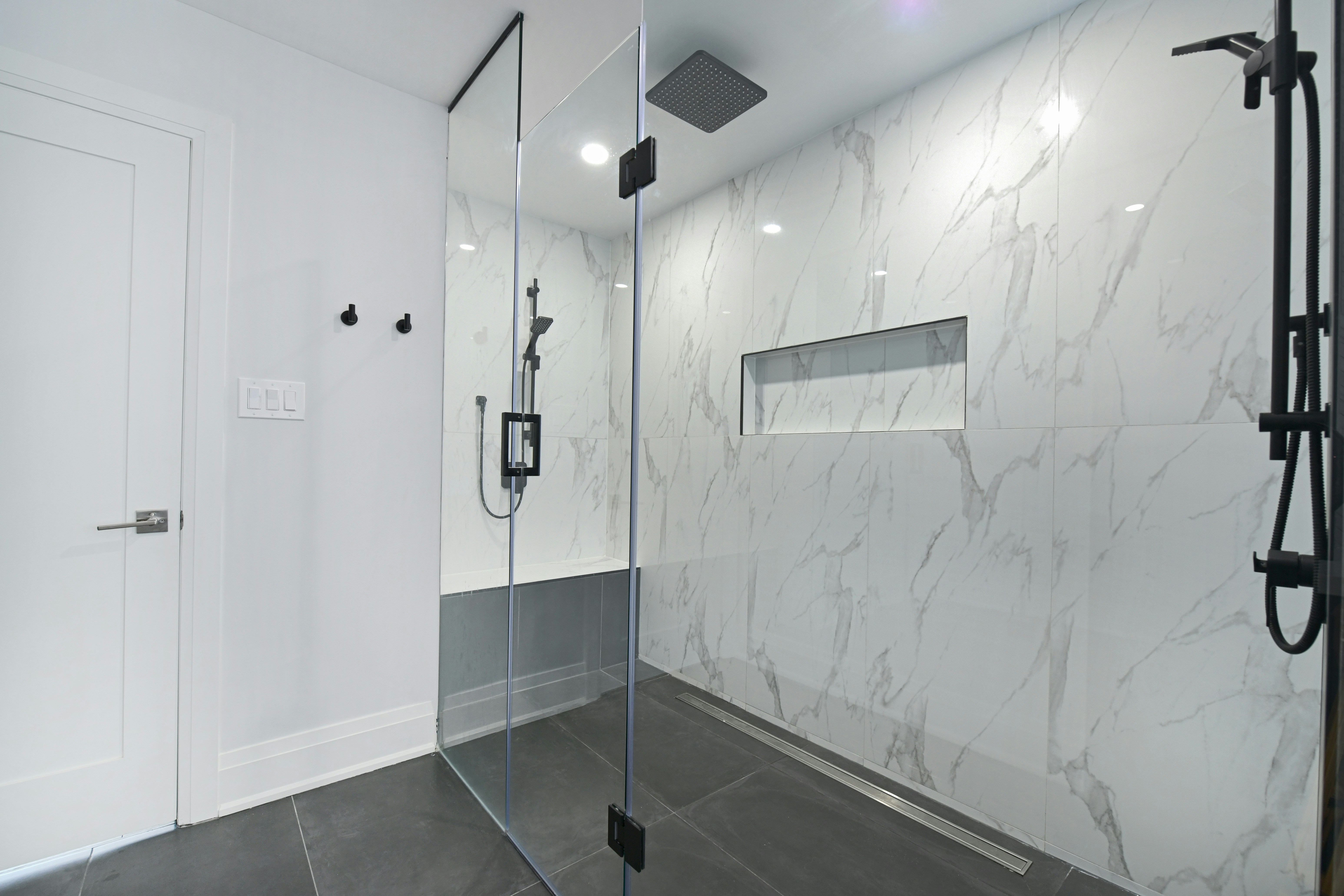 Modern bathroom with glass-enclosed shower and marble walls