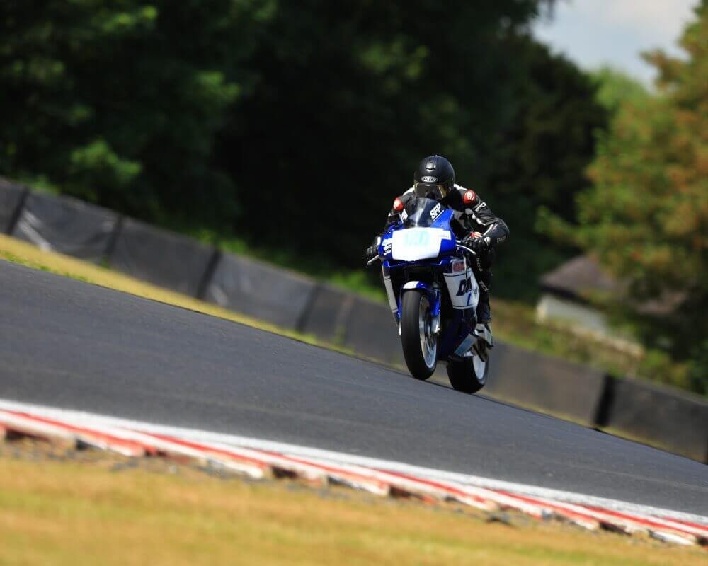 Ollie Moto on his track bike racing down the straight at Oulton Park