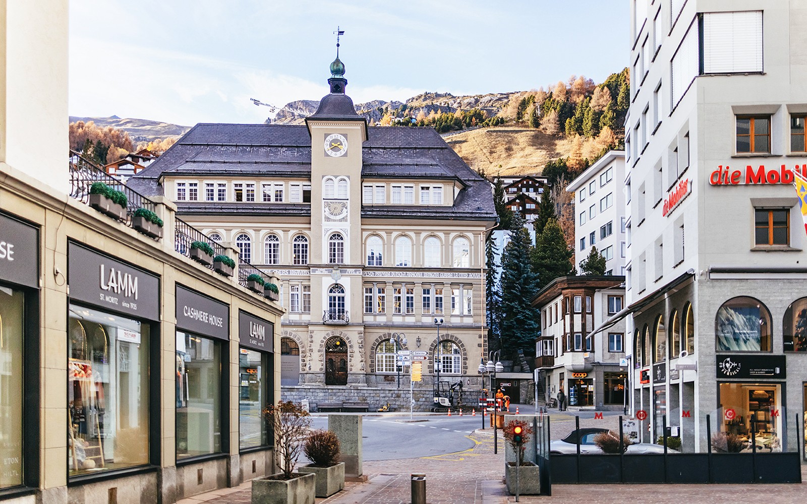 מרכז העיירה סנט מוריץ עם בניין היסטורי ונוף הררי.