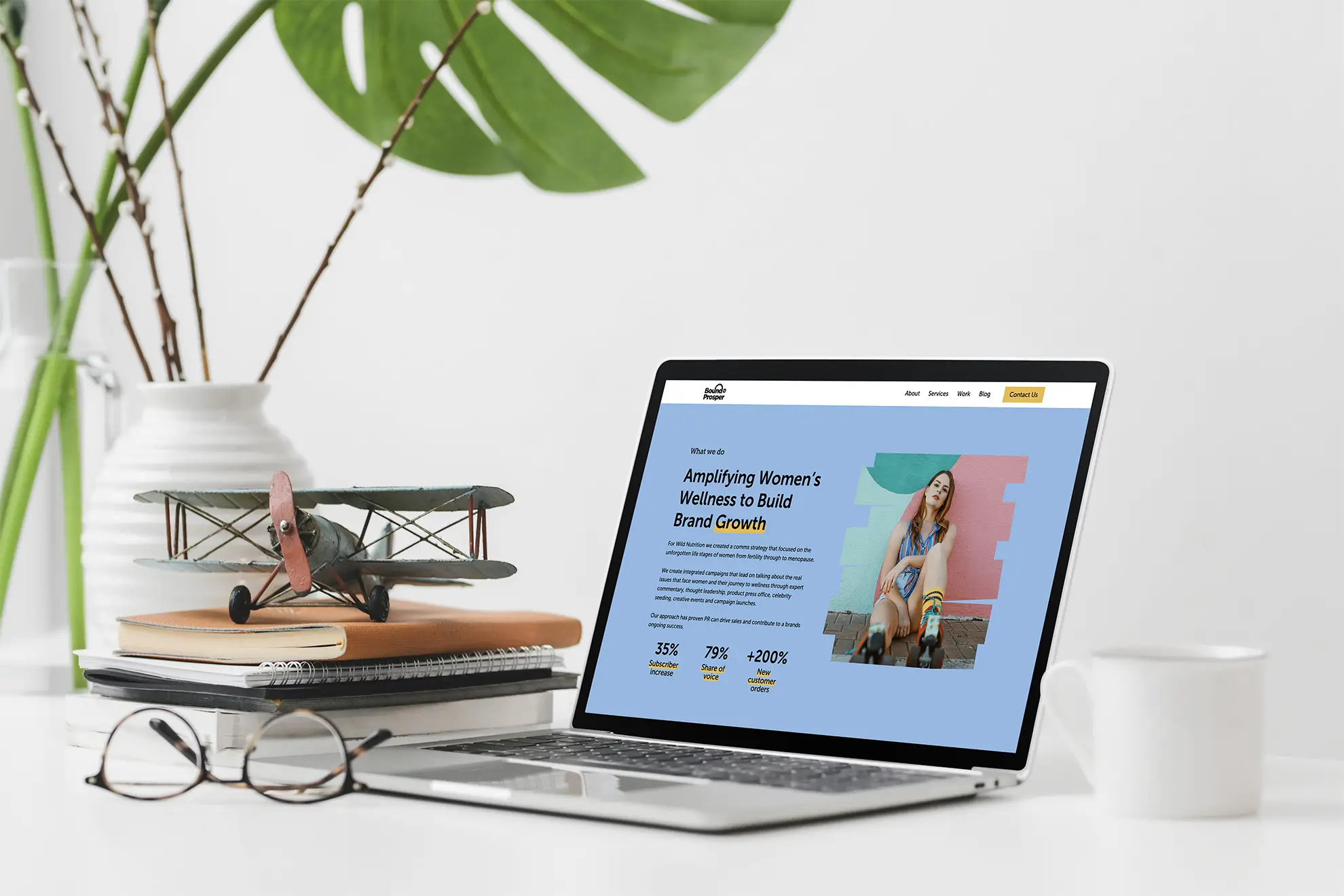 A tablet displaying a colorful design, with books and a plant on a desk.