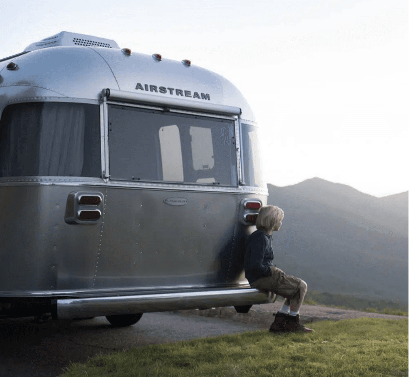 Young by sitting on an Airstream bumber representing works designed by Bart Fish