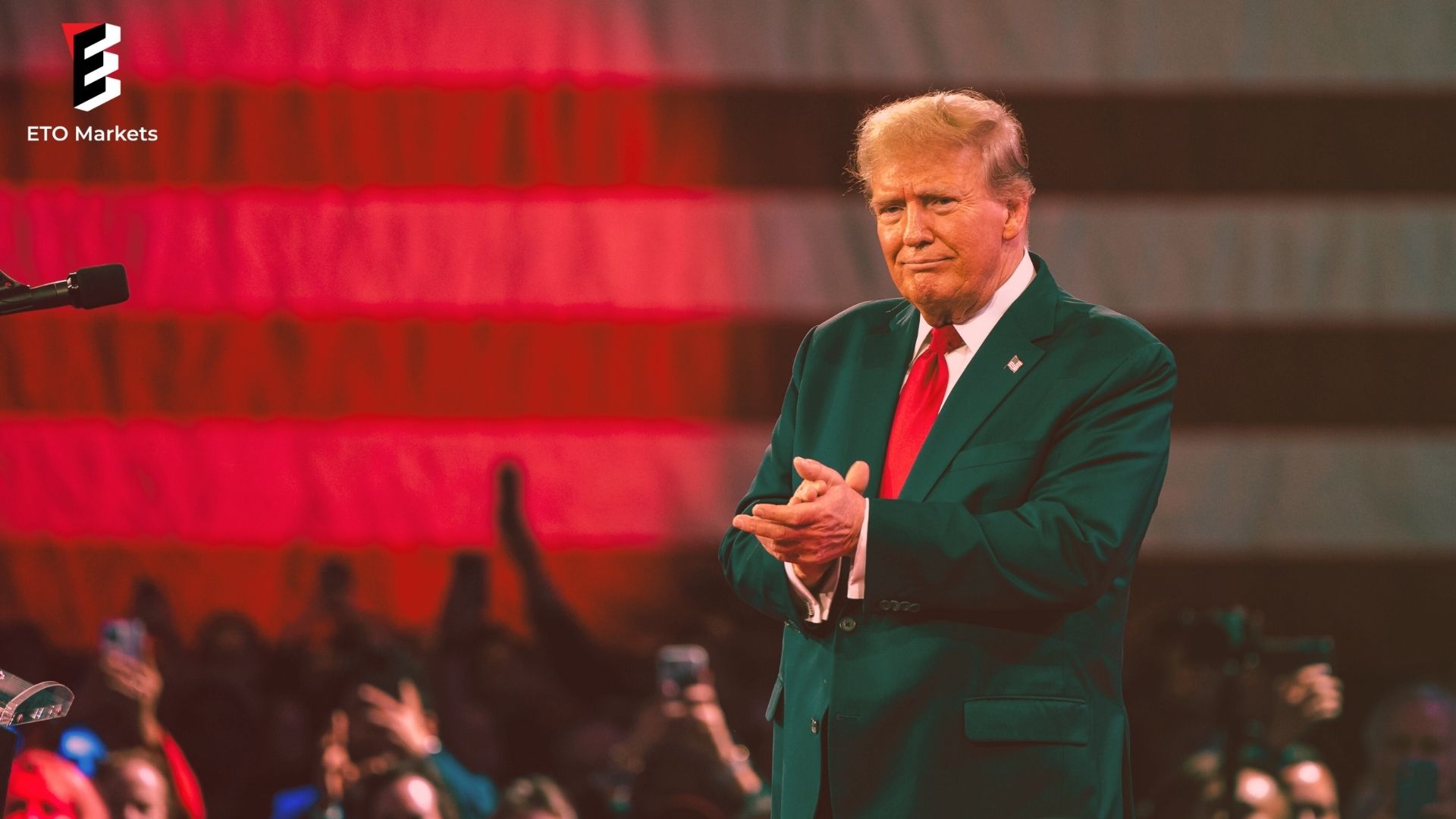 Donald Trump giving a speech, smiling and making a clap.