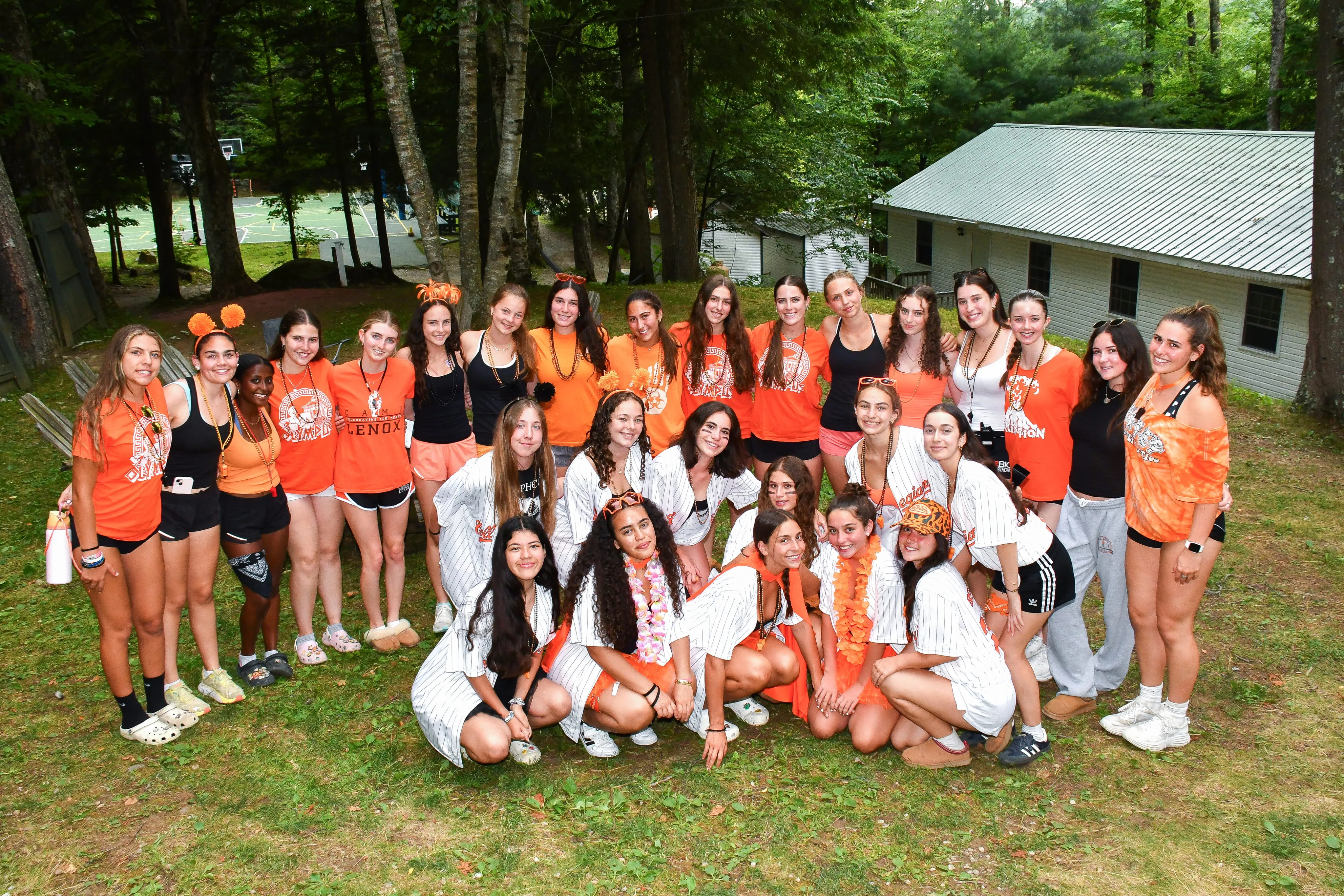 Large group of campers posing together outside a cabin at Camp Lenox