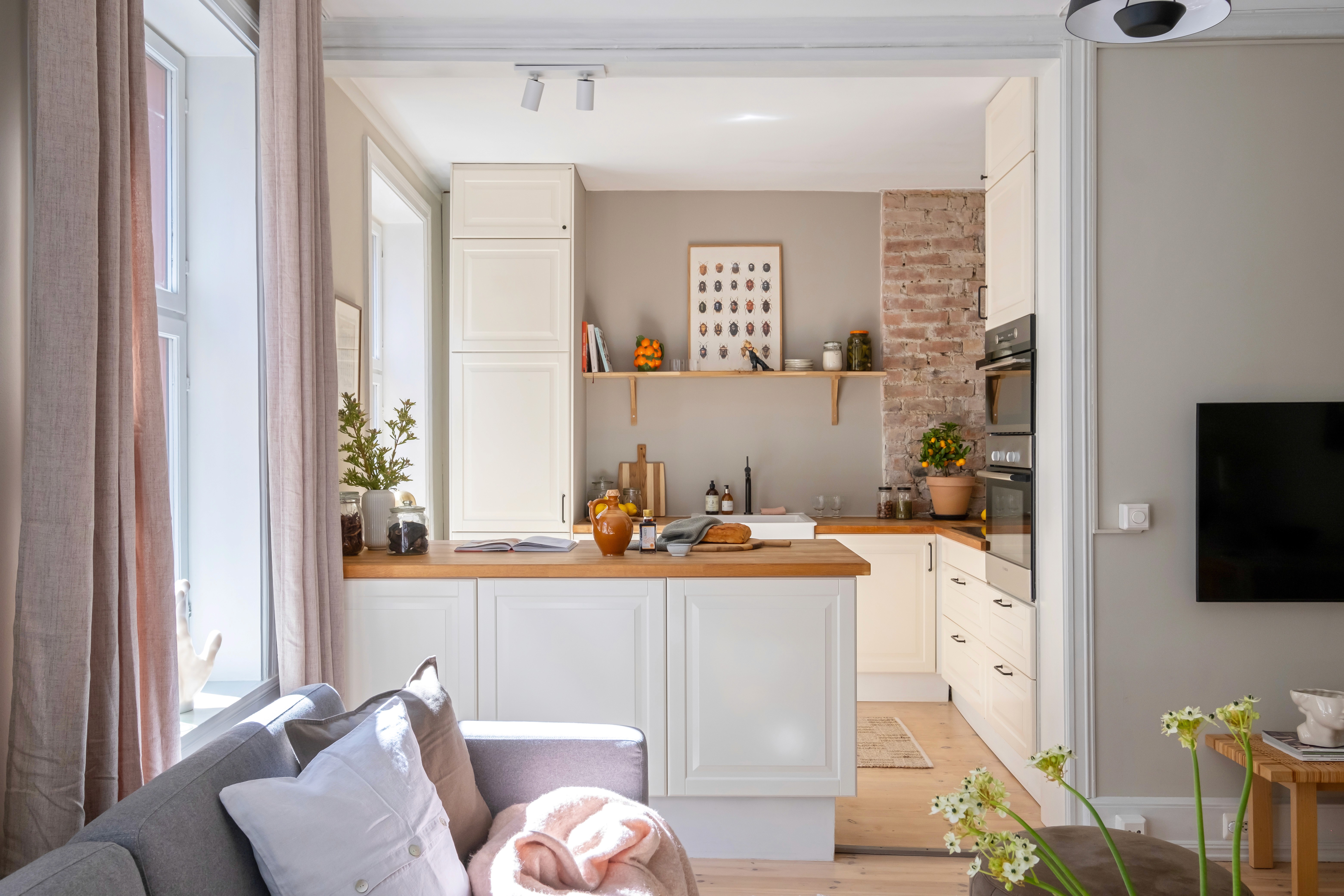 Moderne kjøkken med lyse flater, vindu og dekorative detaljer