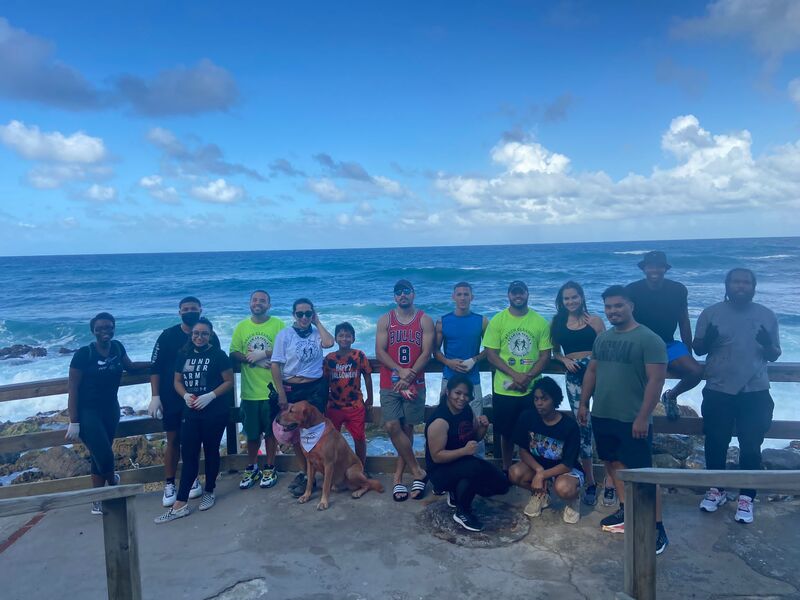 Documentary film crew and subjects posing together by the ocean in Puerto Rico