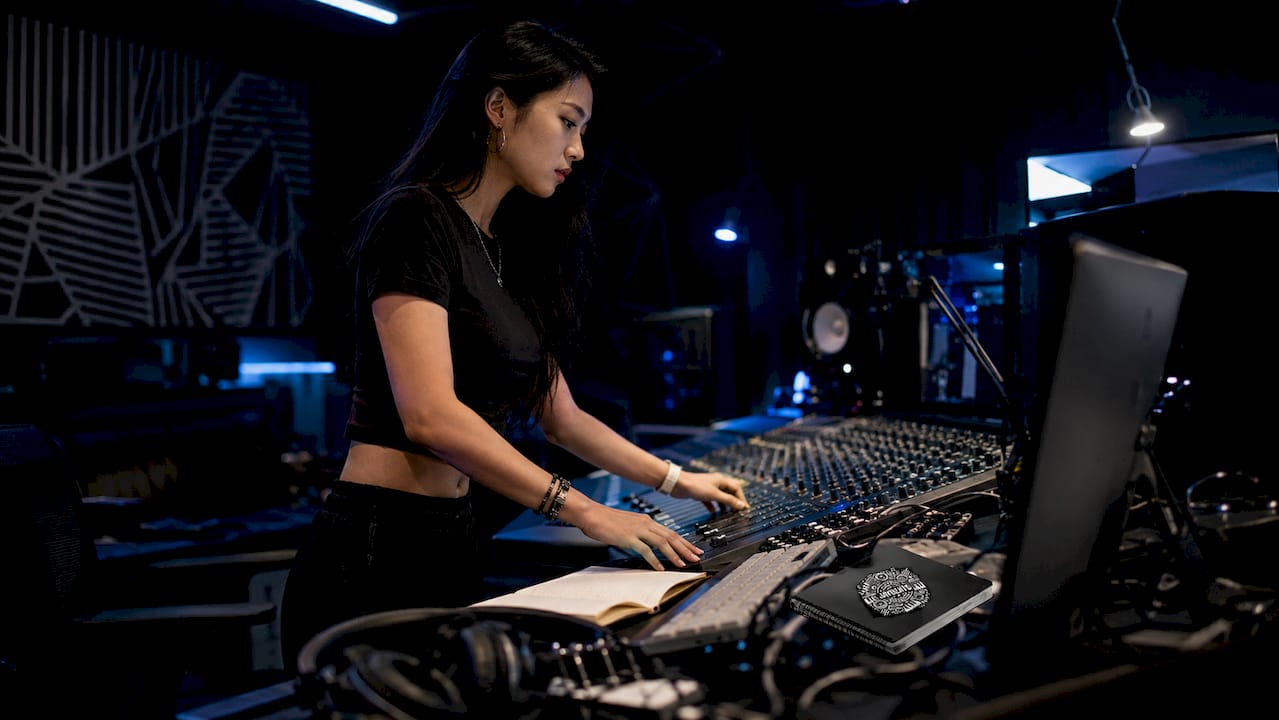 Female producer creating beat in booth