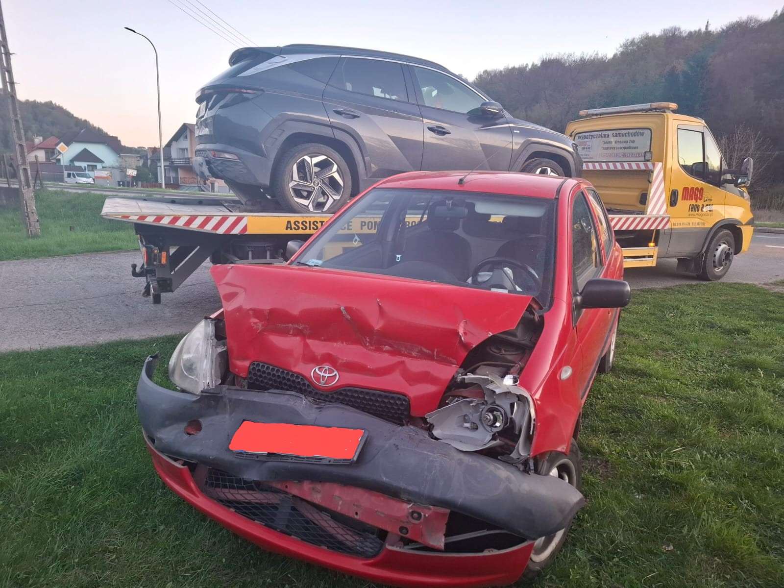 Uszkodzony samochód po kolizji przygotowany do transportu lawetą