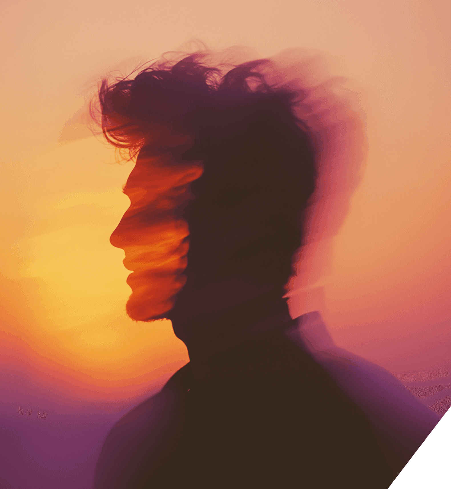 A man is positioned in front of a colorful sunset, showcasing shades of orange and pink illuminating the evening sky.