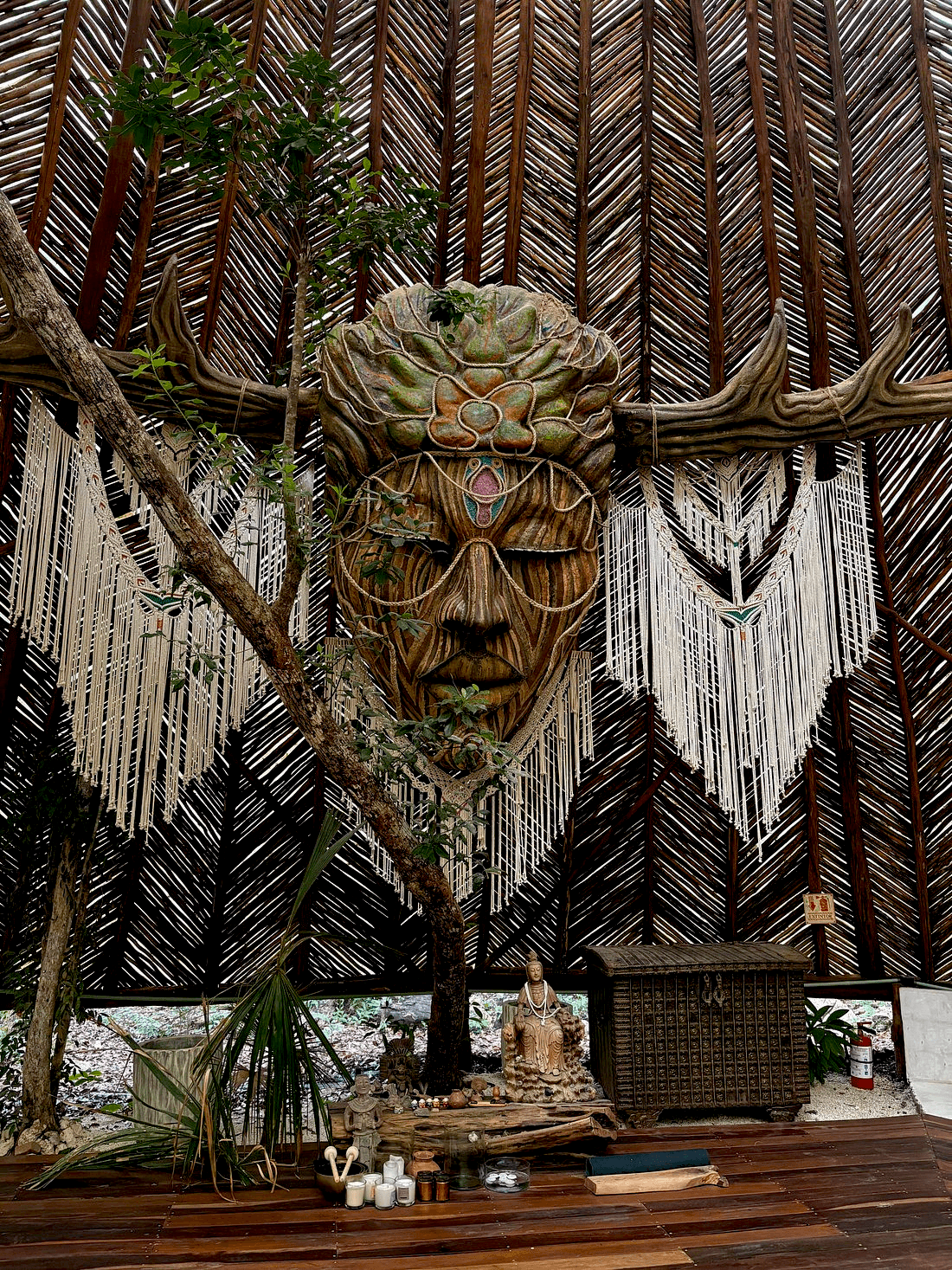 A rustic outdoor dining table set with wine glasses, cutlery, bread, and olives sits amidst lush vineyard rows, with a historic Tuscan villa in the background under a serene sky, capturing the essence of a picturesque Italian countryside landscape.