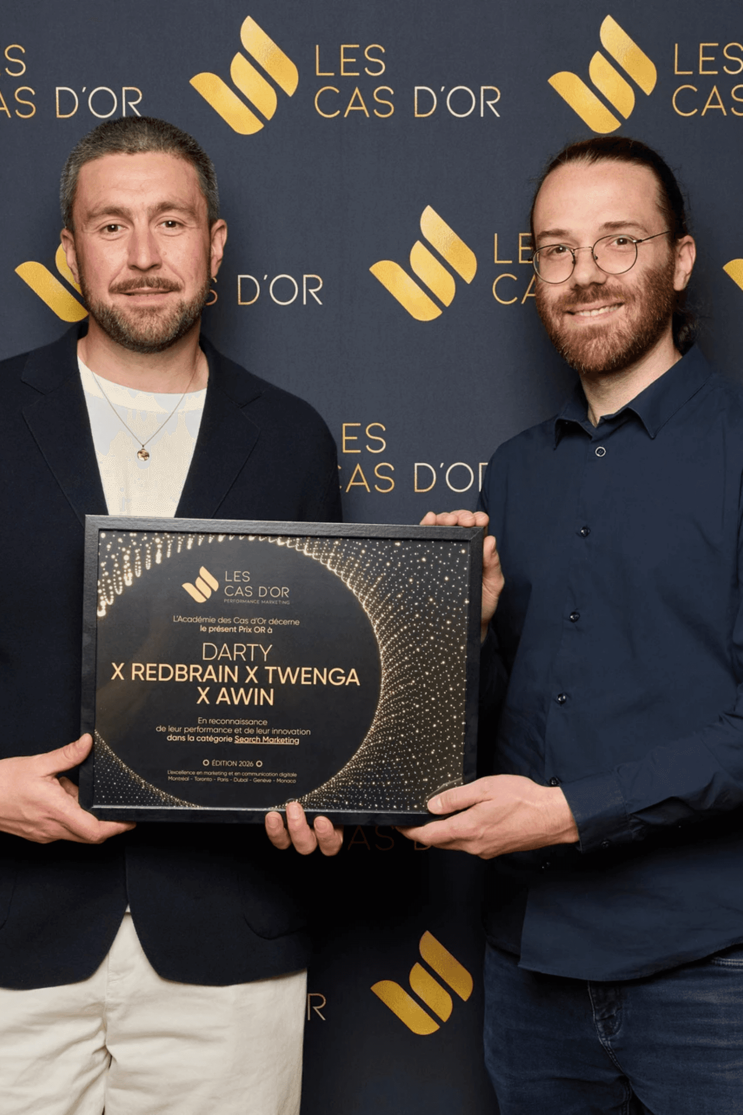 Young man in a formal outfit with a striped shirt, grey tie, and black coat. The tone is serious and professional, emphasizing subdued elegance.