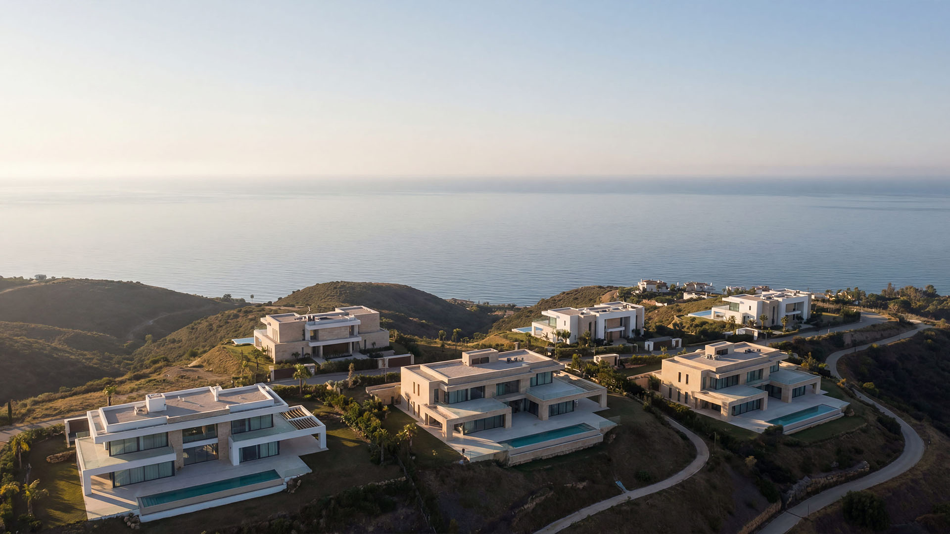 Aerial view of modern luxury villas in Marbella hills with sea view and private infinity pools